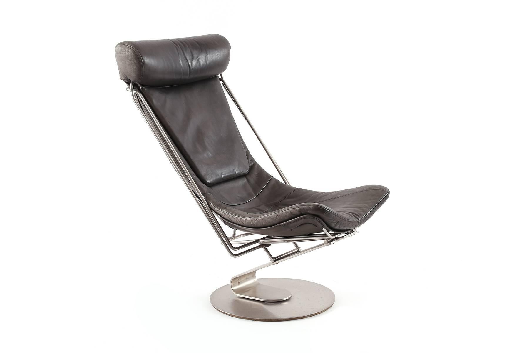 Cantilevered steel and leather chair and chaise from Denmark. This all original example cleverly converts from a chair to a chaise. The back cushion and chrome arms easily pull down and become the footrest! Ingenious and beautiful. As a chair the