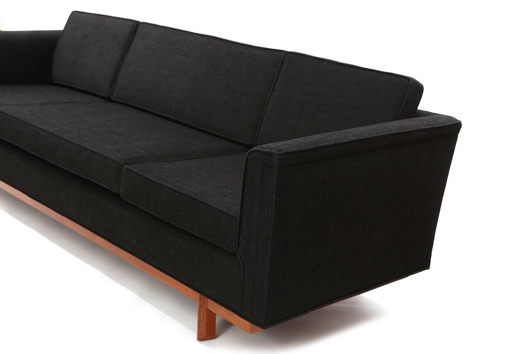 Frank Lloyd Wright for Heritage Henredon sofa circa early 1960's. This example has a solid mahogany base with the Taliesin detail carved into the legs. It has been newly upholstered in a striking black textile with linen colored accents. Retains its