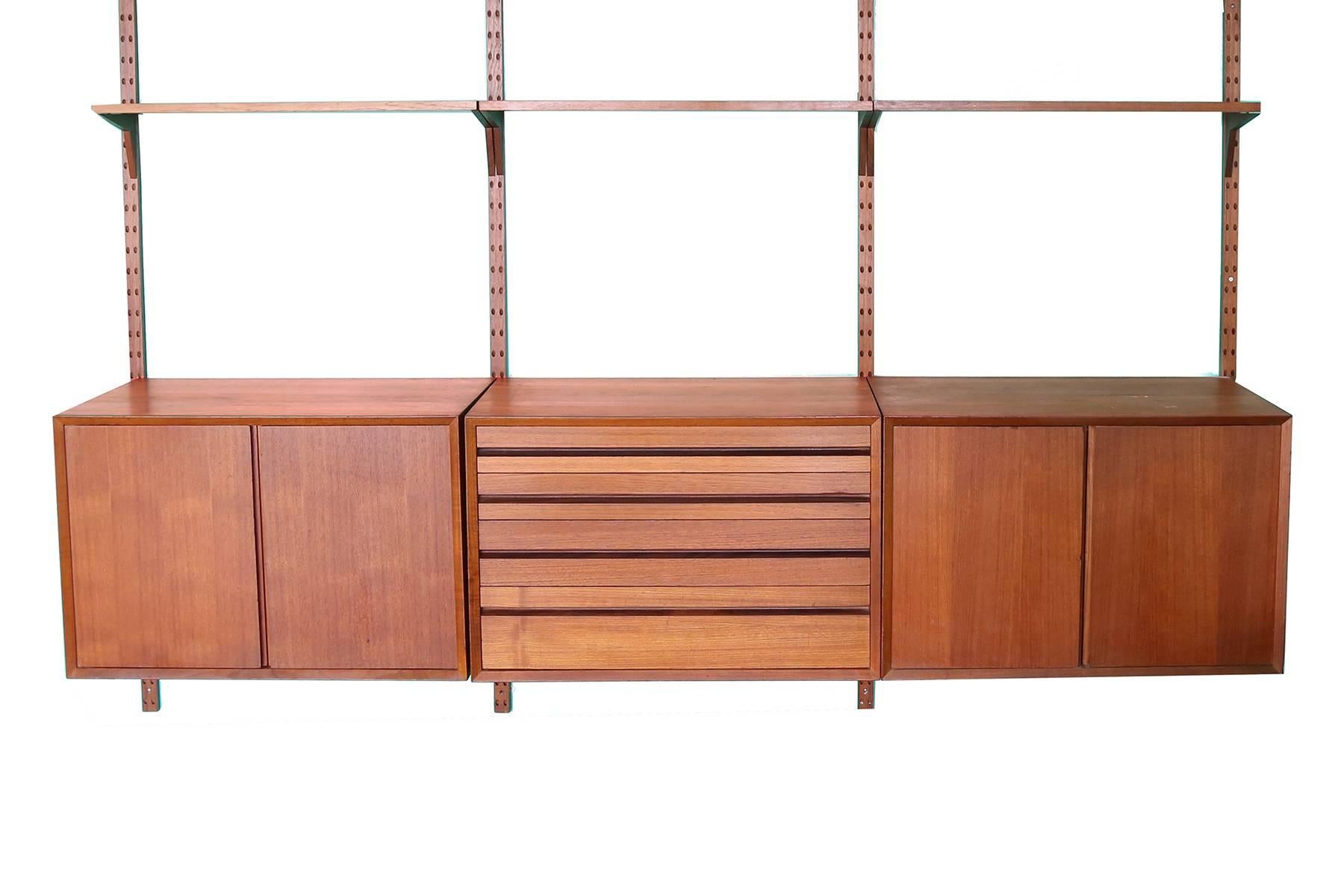 Poul Cadovius for Cado teak wall unit, circa mid-1960s. This example’s has four teak posts, two teak chests (one with one shelf, other with pull-out drawers, one four drawer chest, three shelves, one drop down teak cabinet and two teak and glass