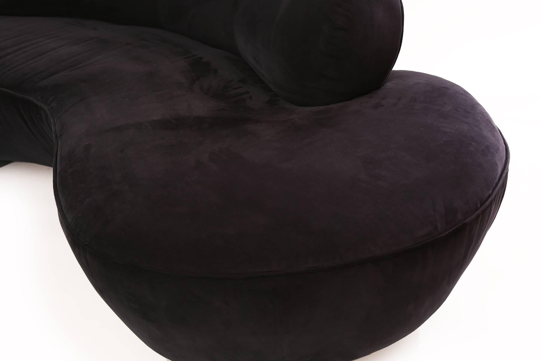 Vladimir Kagan for Directional serpentine sofa. This all original sculptural example is upholstered in a plush and rugged black ultra suede. It has two upholstered circular bases and Lucite support. Retains directional label.