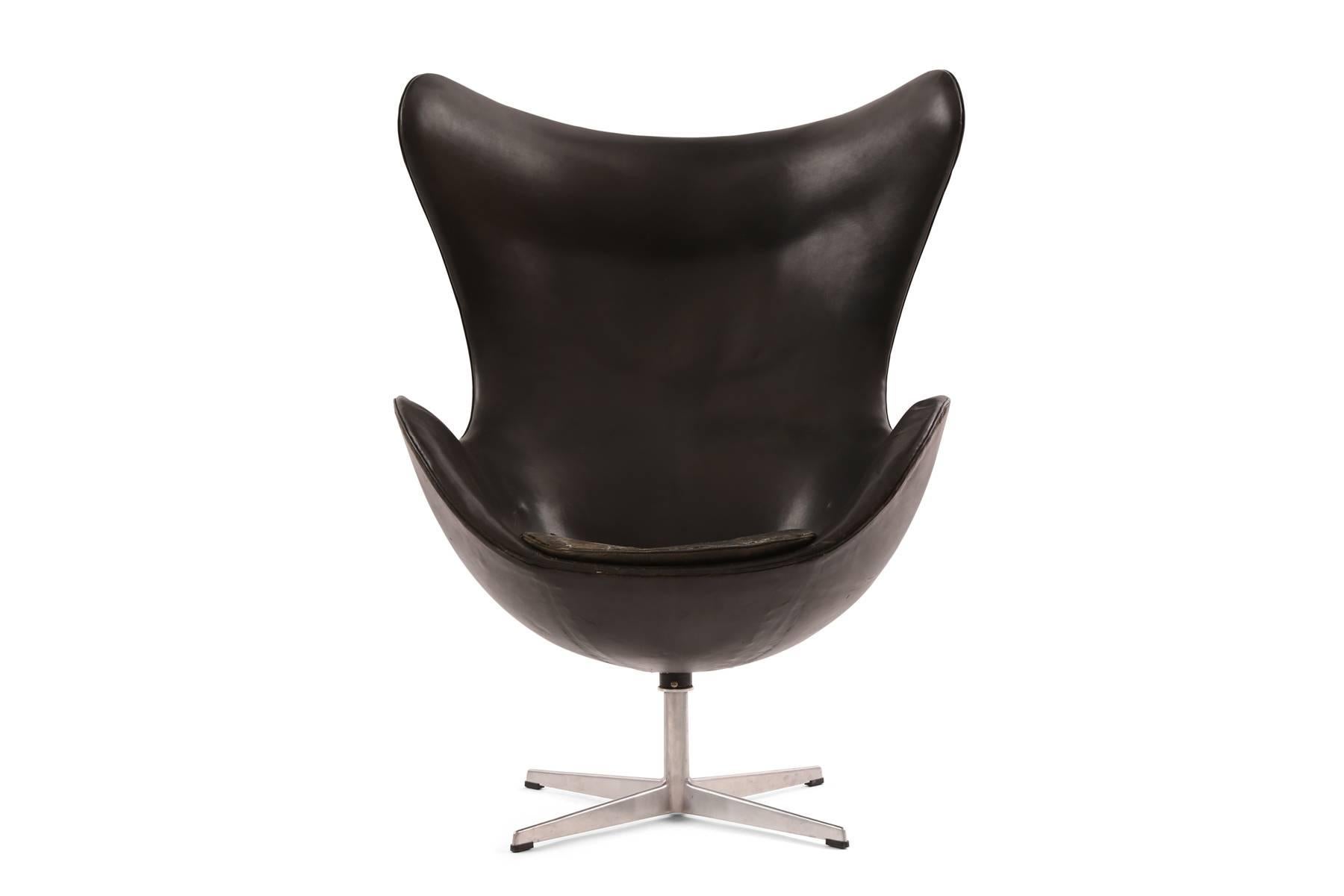 Arne Jacobsen for Fritz Hansen first generation leather egg chair, circa late 1950s. This example has beautifully patinated black leather black leather upholstery and can be used with or without the seat cushion. Has some internal drying to the foam