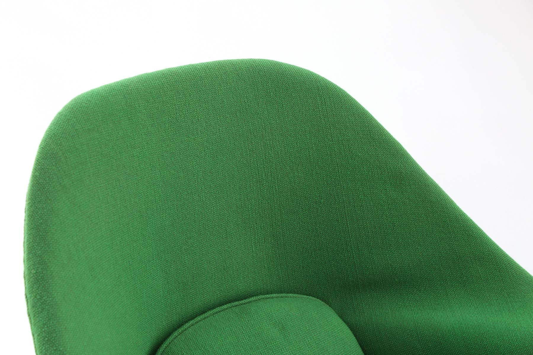 Early production Eero Saarinen Knoll womb chair and ottoman. This example has a black iron frame and is upholstered in a stunning kelly green upholstery. There is wear to the left arm and there is additional fraying on the back. It can be used in
