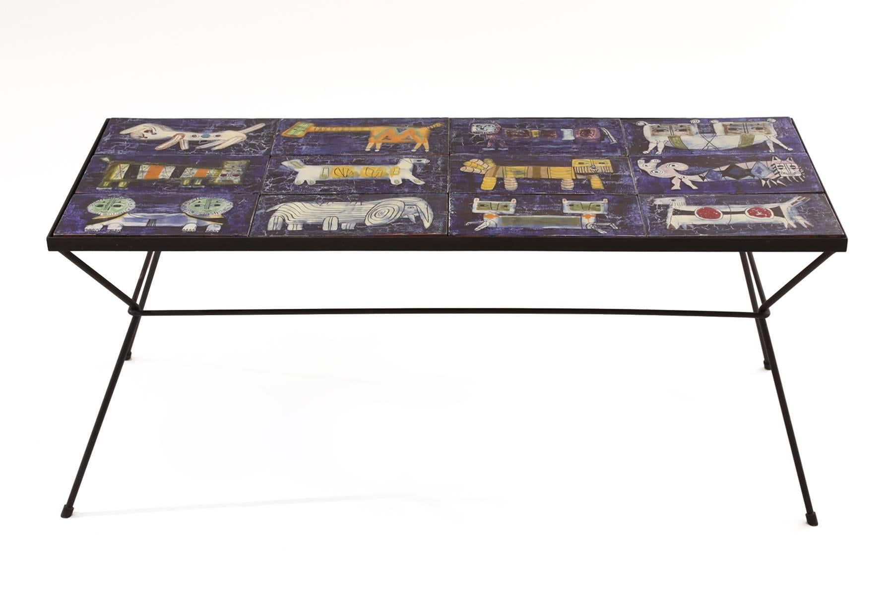 Ceramic tile and wrought iron coffee table from Italy, circa late 1950s. This example is composed of 12 hand-painted and glazed animal motif ceramic tiles inset in a patinated iron table base. The tiles are loose so can be arranged in the pattern of