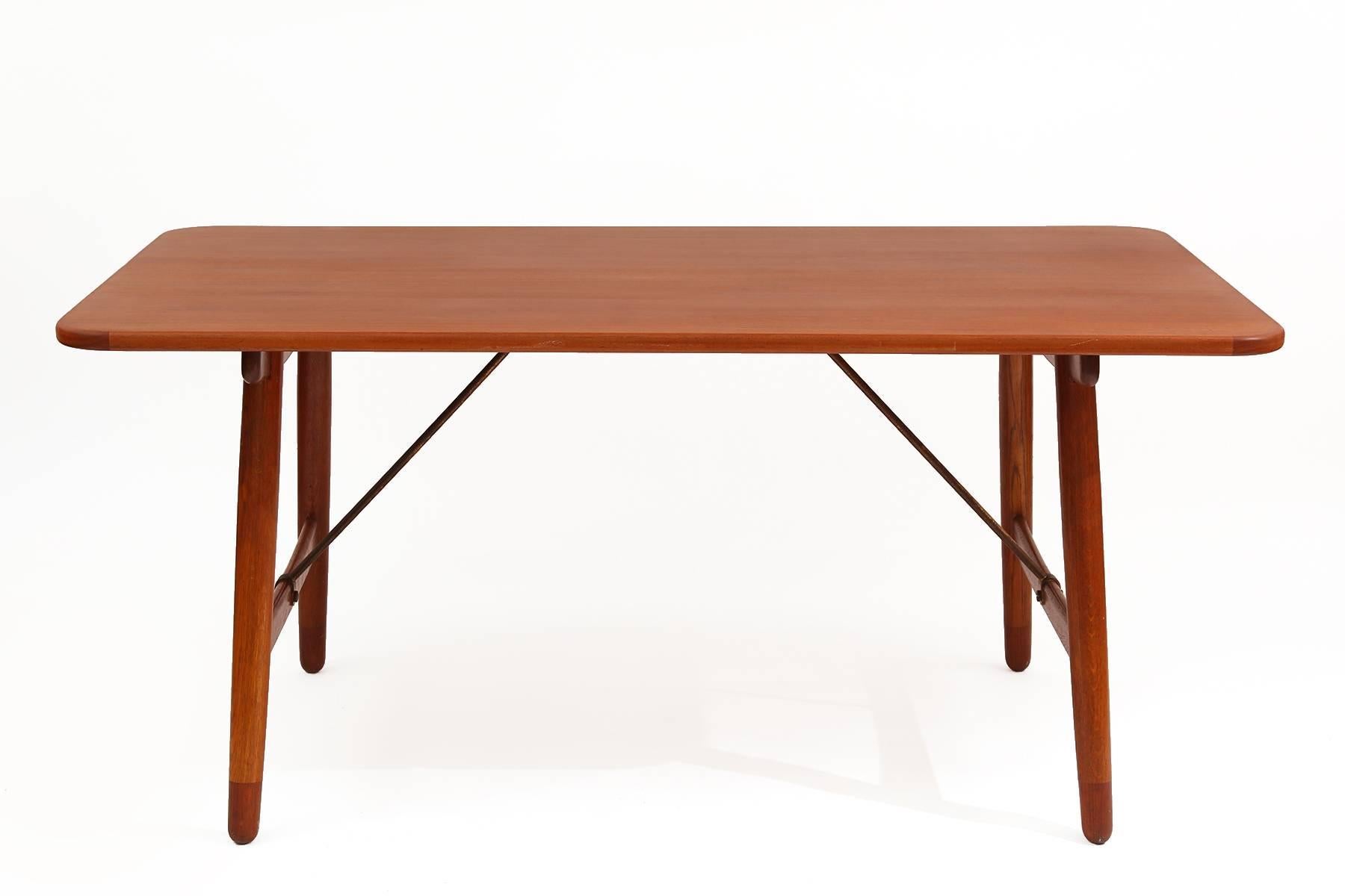 Borge Mogensen hunting dining table, circa late 1950s. This seldom seen example has a beautifully grained solid teak top, patinated brass stretchers and solid teak legs.
