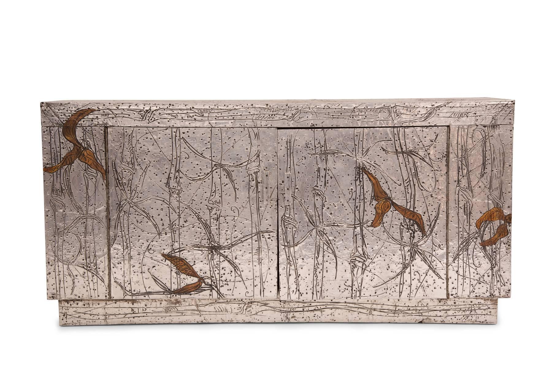 Arenson studios aluminum and copper credenza or chest, circa late 1950s. This extraordinary example employs hammered and etched aluminum and copper over a wood structure. It is signed on the top and back.