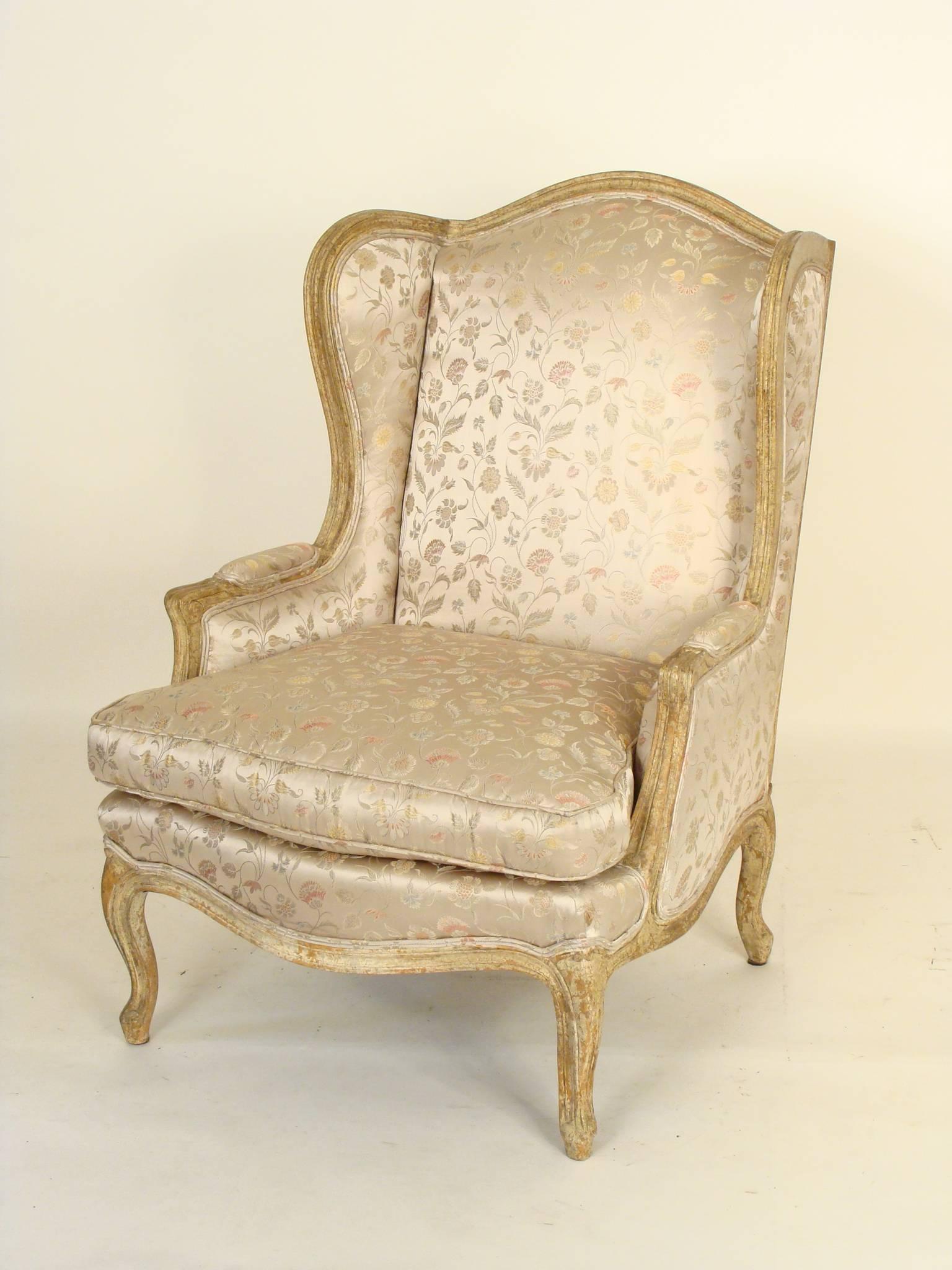 Pair of Louis XV style provincial painted winged bergeres, circa 1980. These chairs have excellent stabile crackled crusty painted surfaces.