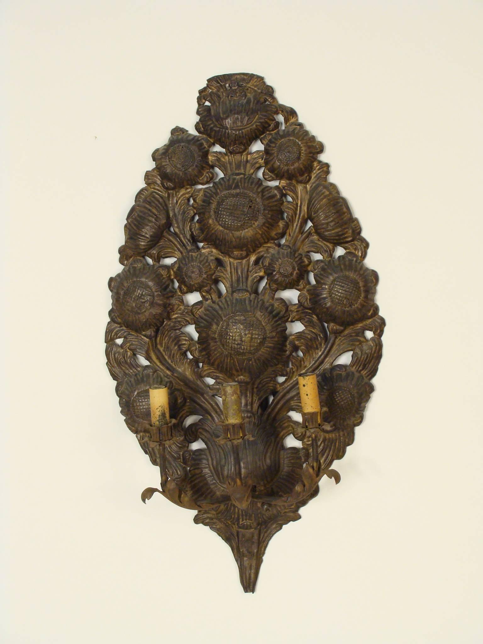 Pair of continental Baroque style brass repoussee three branch wall sconces, 19th century.