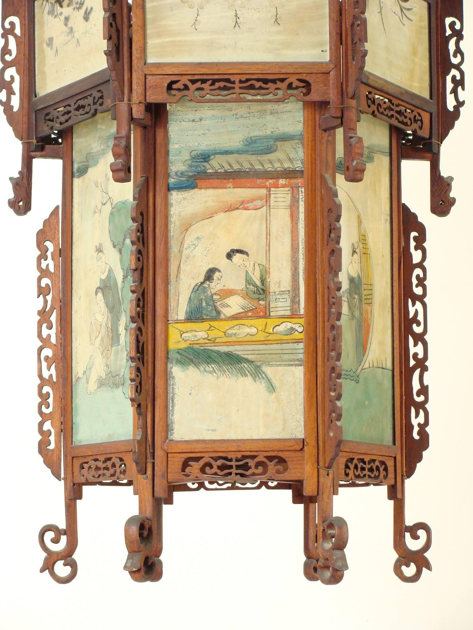 Chinese lantern with églomisé glass panels, circa 1940. This is a very colorful and decorative lantern with stylized wood carved dragons and églomisé glass panels.