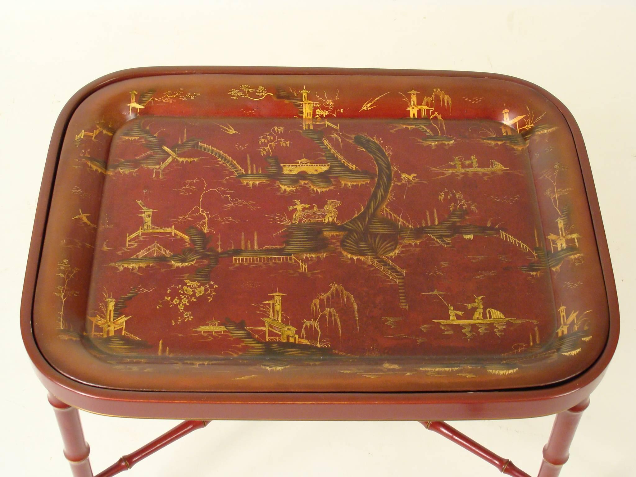 Red chinoiserie decorated tole tray, 19th century on a late 20th century English Regency style bamboo turned stand.