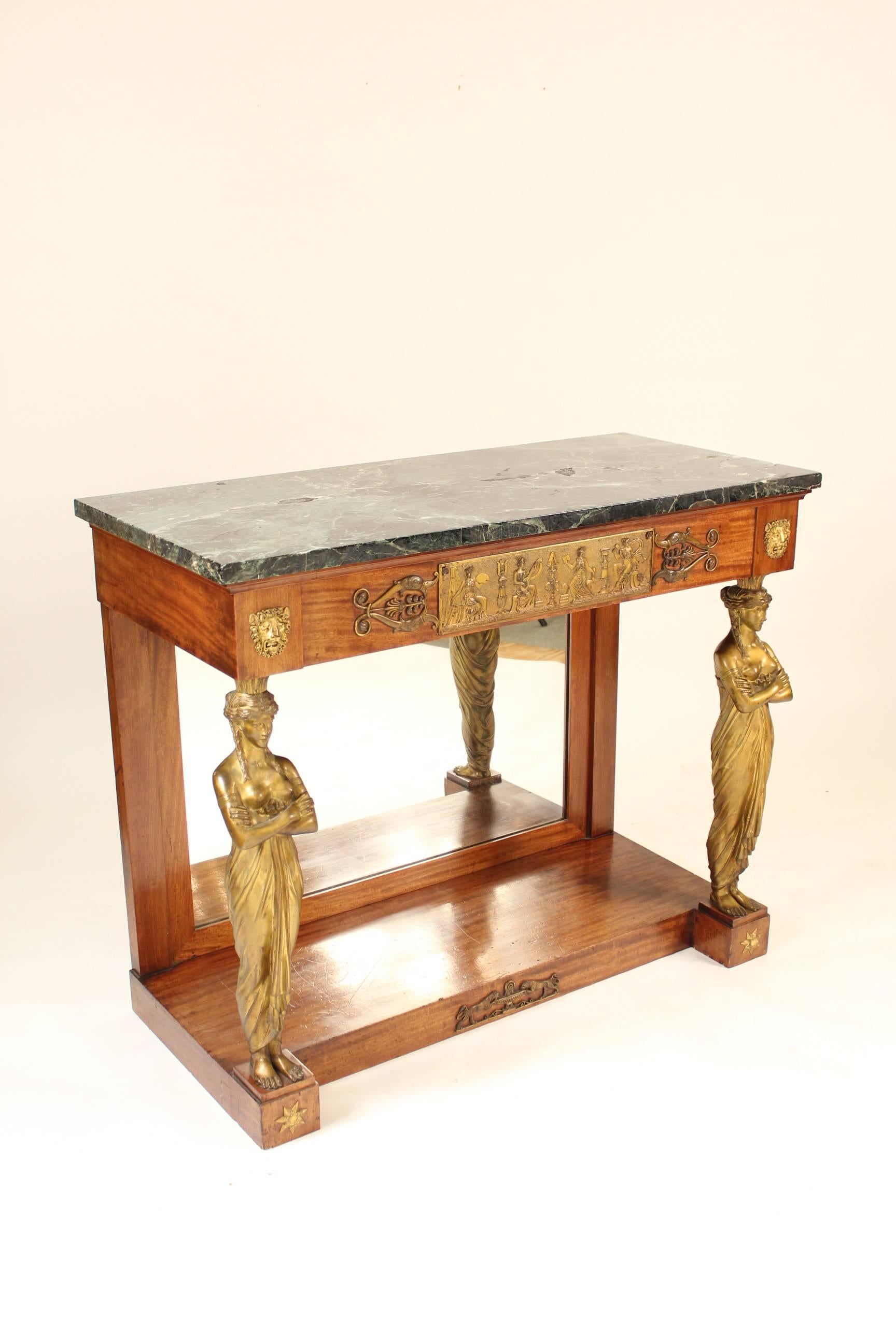Empire style gilt bronze-mounted mahogany console table with a green marble top, circa 1920. Having a rectangular marble-top, a frieze with a bronze plaque with four muses, supported by two large gilt bronze caratid's.