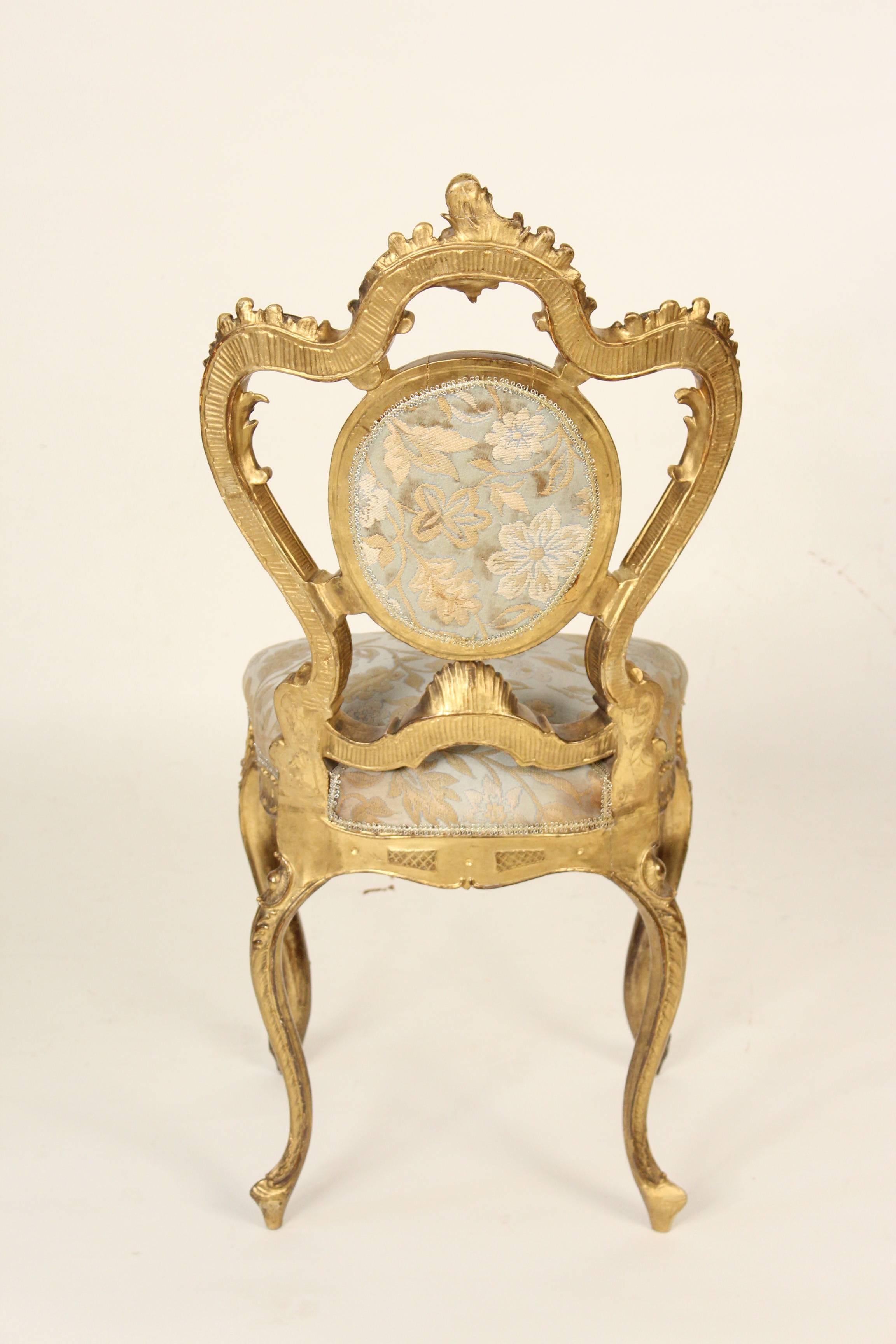 Rococo Revival giltwood vanity or slipper chair, circa 1890. This gem of a chair has fun exaggerated Rococo lines. There was a tremendous amount of skill involved in sculpting and carving this chair, it retains its original gold leaf finish. There