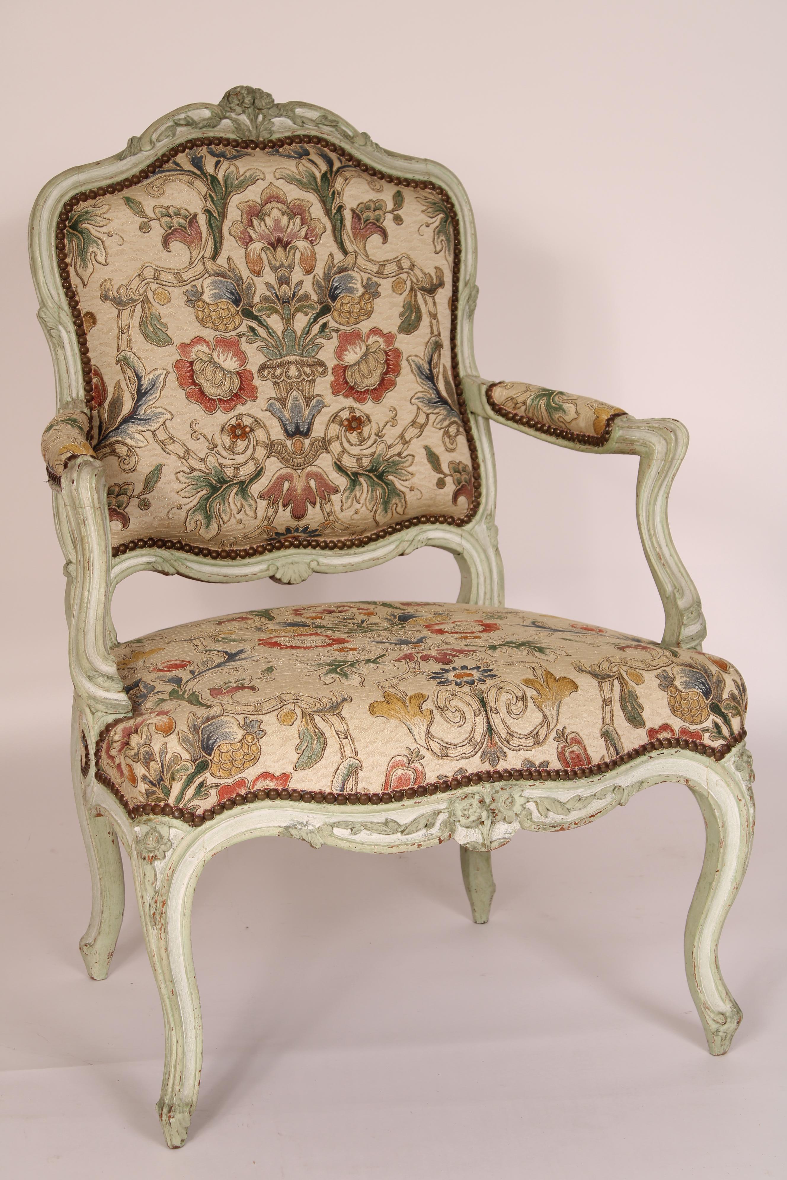 Paire de fauteuils peints de style Louis XV, fin du 19e siècle. Le dossier est rembourré, les supports d'accoudoirs sont en forme de serpentin et les accoudoirs sont rembourrés,  tabliers d'assise avec sculpture florale centrale, reposant sur des