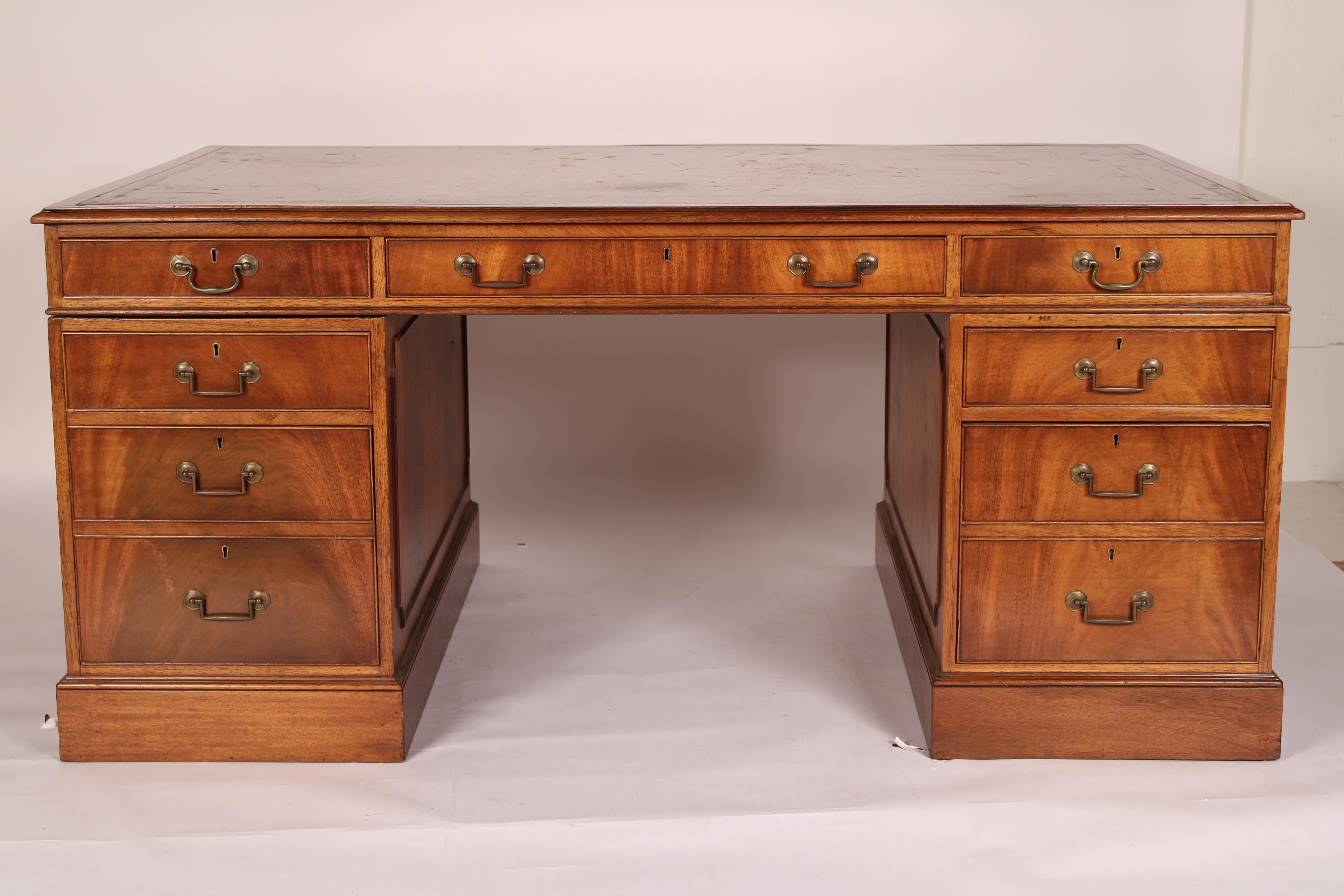 Scrivania in mogano a fiamma in stile Giorgio III con piano in pelle lavorata, circa 1960. Con un piano con inserti in pelle lavorata, bordi in mogano e bordi modanati con il pollice, il lato anteriore della scrivania con 3 cassetti a fregio, sotto
