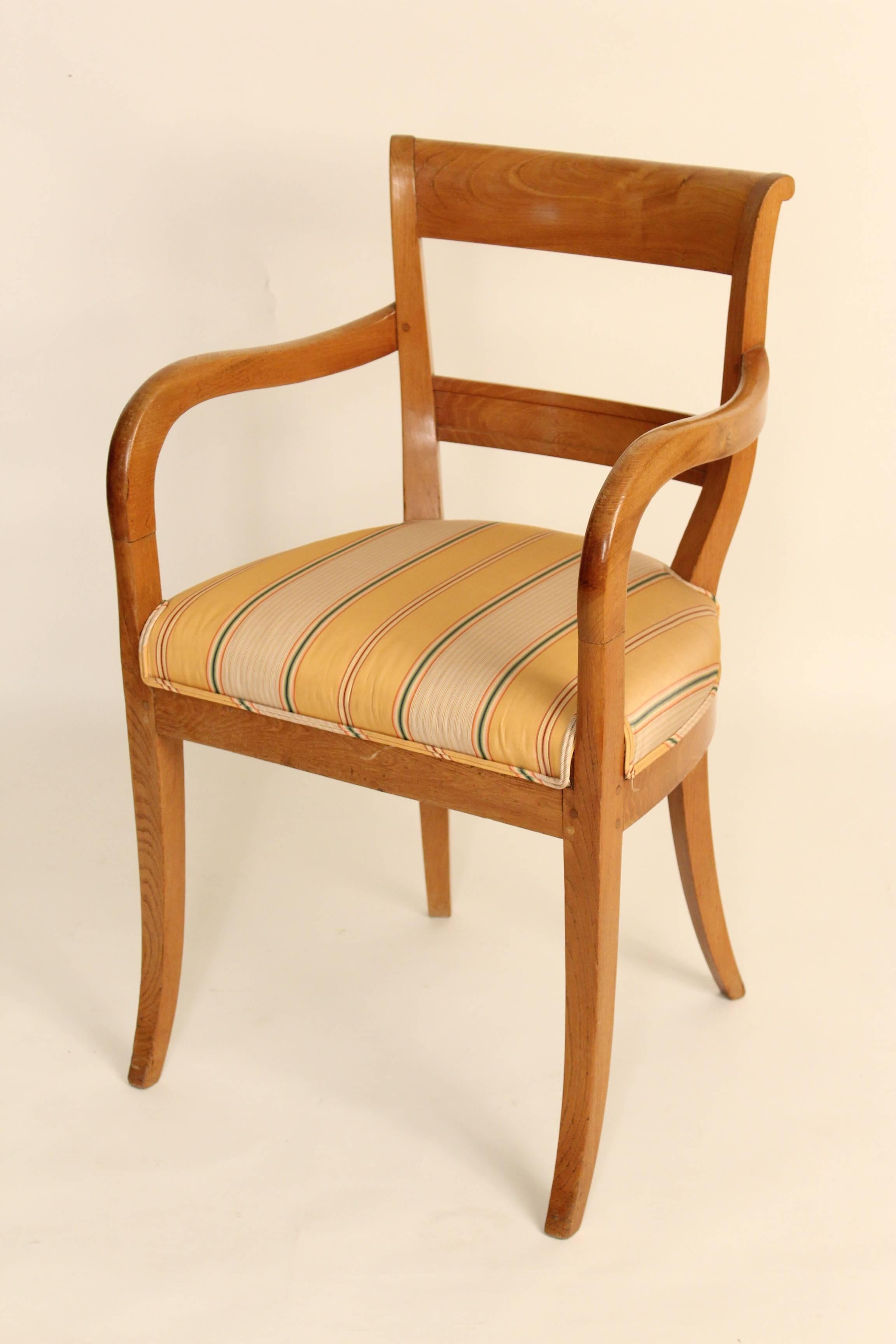 Directoire style chestnut dining room chairs, circa 1910. There are two-arm and four side chairs to the set. The chairs have pegged construction. Dimensions on armchairs, height 34.5