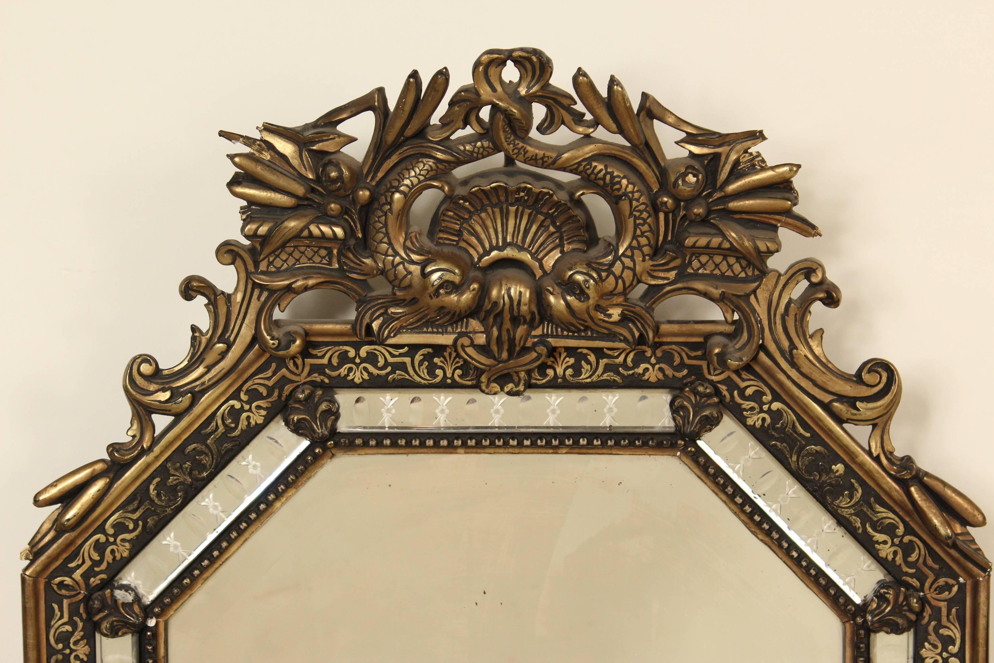 Napoleon III style giltwood octagonal shaped mirror, circa 1900. This mirror has an interesting pediment with dolphins and an etched glass outer glass border.