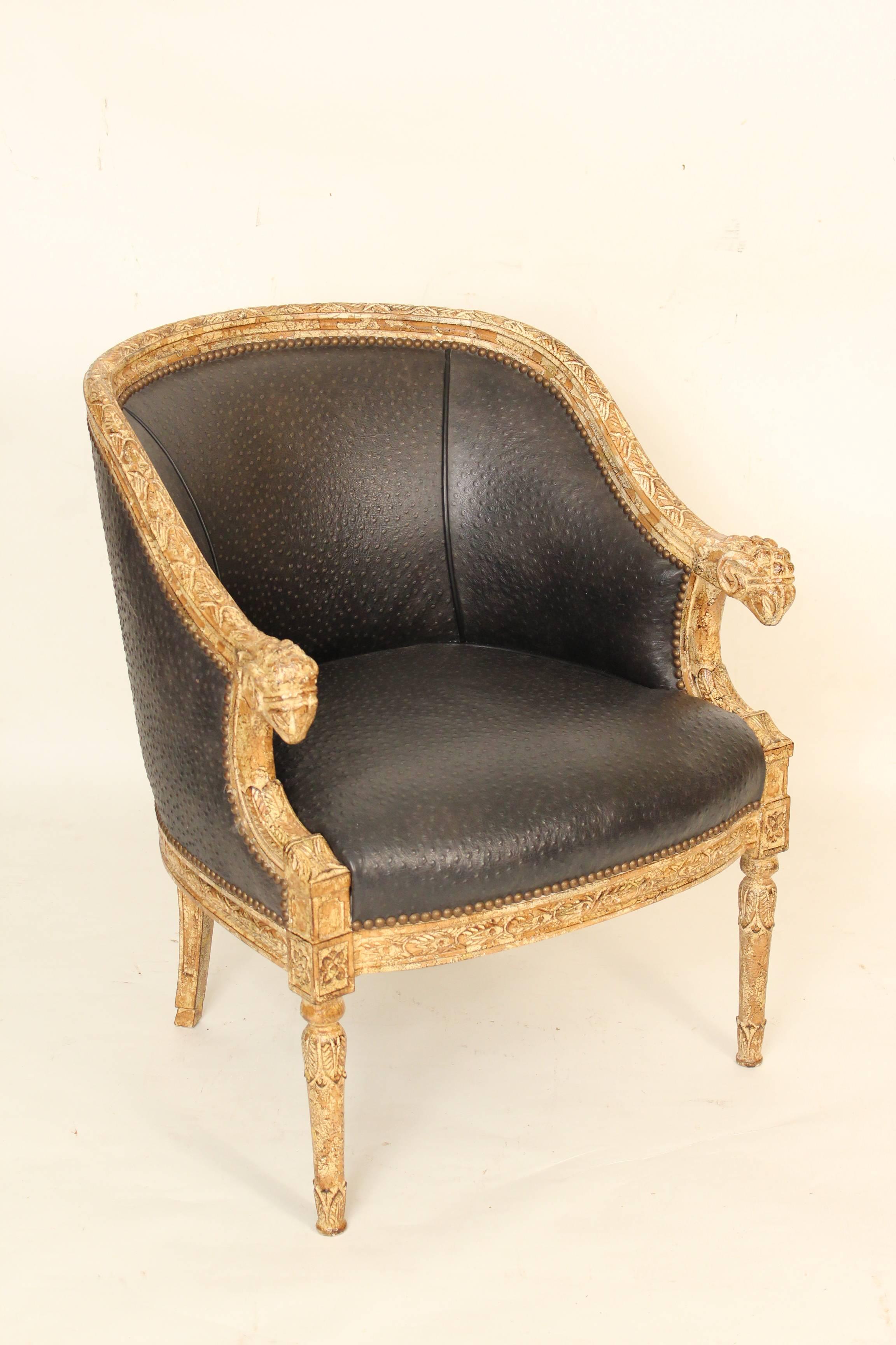 Pair of painted neoclassical style bergeres with ram's head carved arms and faux ostrich leather upholstery, circa 1990s.
