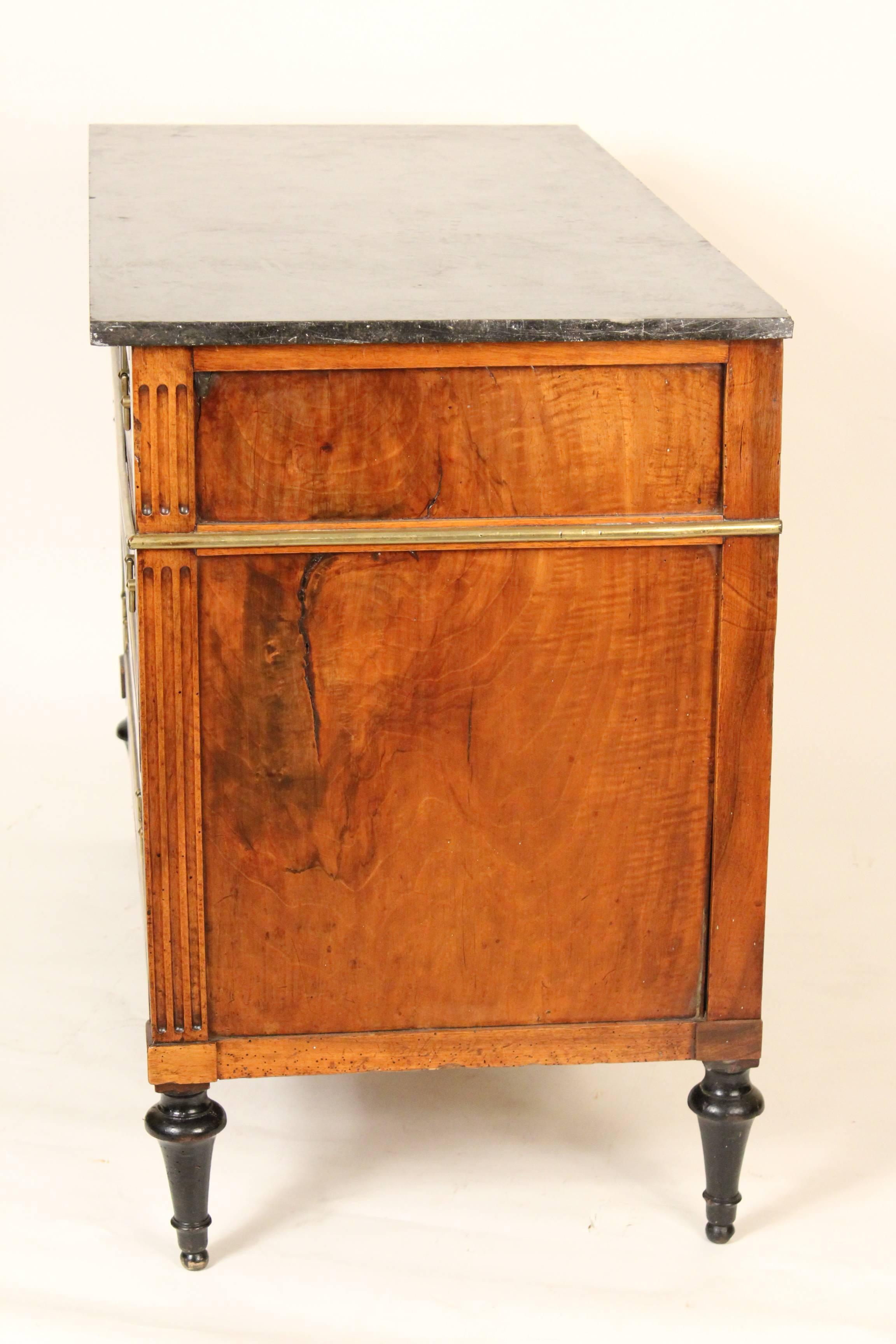 Louis XVI walnut chest of drawers with brass mounts and inlay with a marble top, early 19th century.