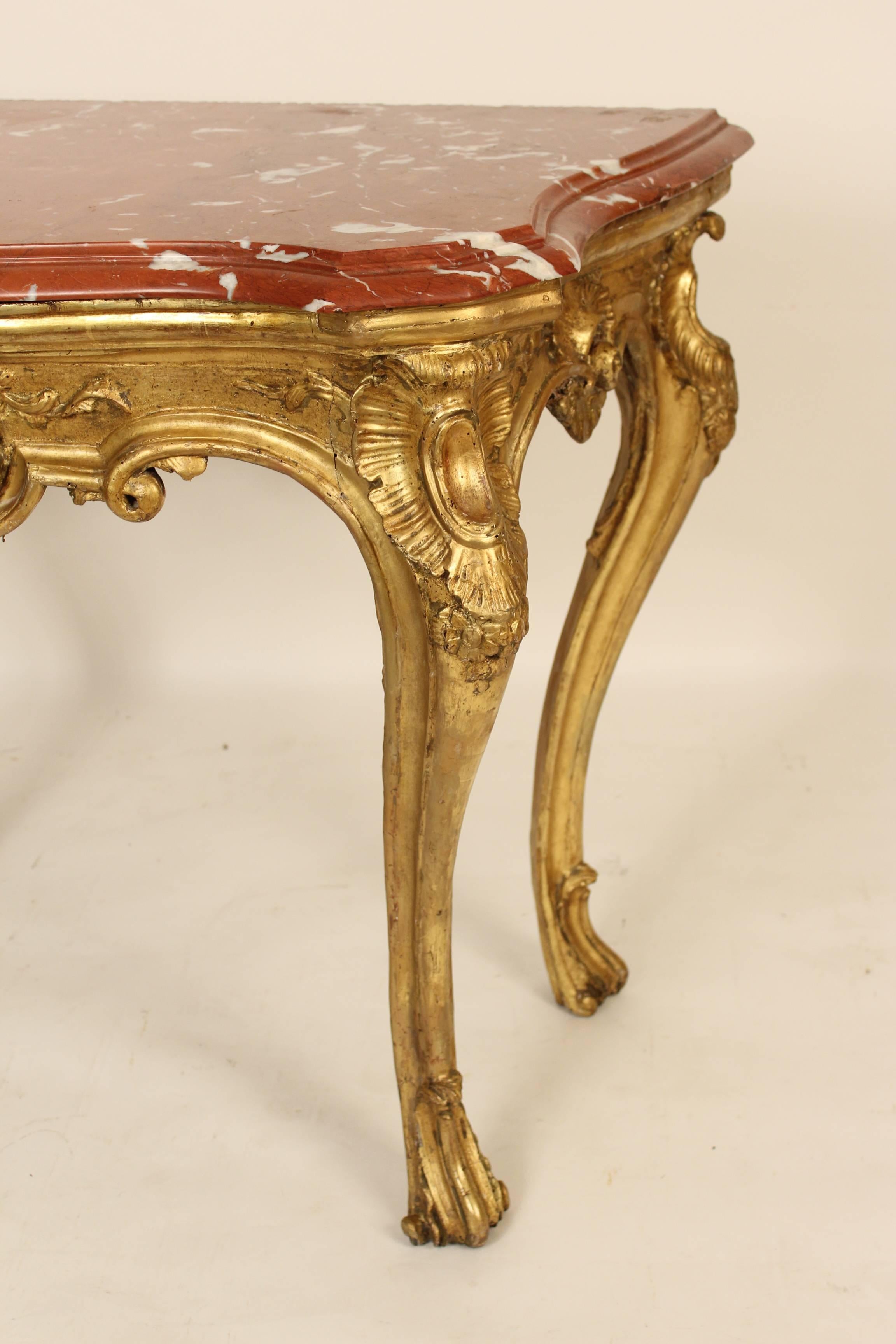 Louis XV giltwood console table, 18th century. The rouge marble top is late 20th century.