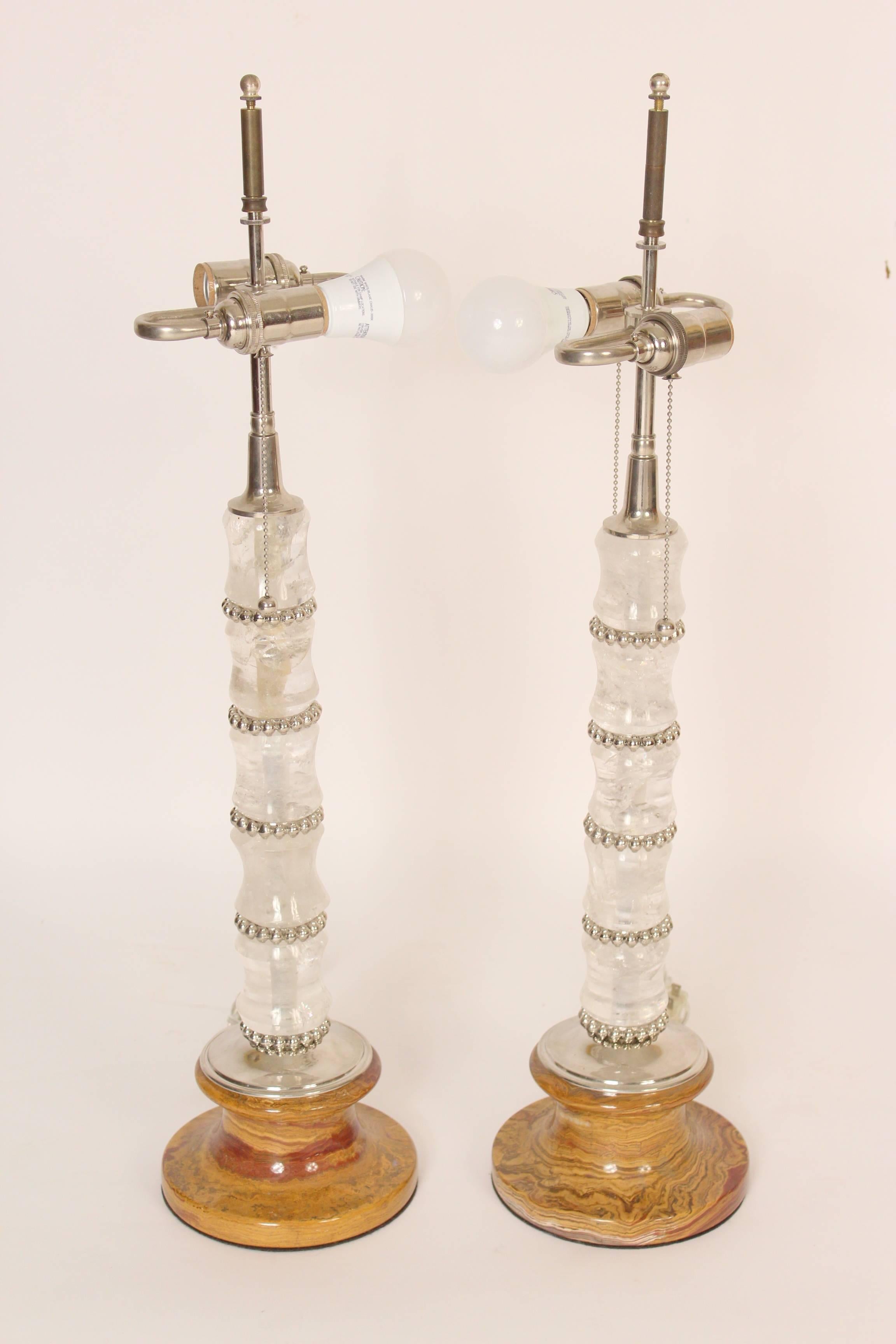 Pair of spool turned rock crystal and marble table lamps with polished nickel hardware, circa 2000. The height from the marble base to the beginning of the electrical fitting is 19