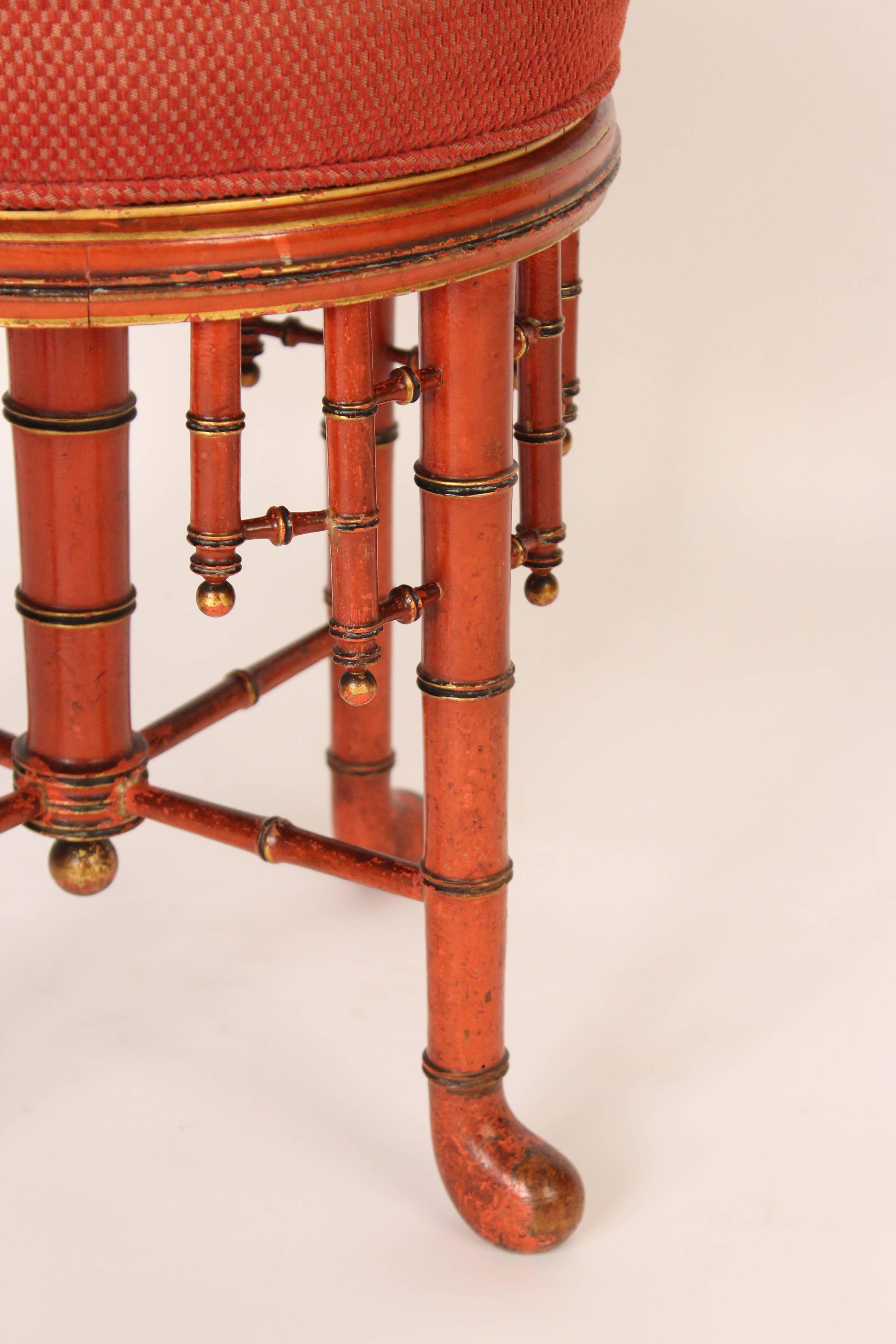 Napoleon III style red painted and partial-gilt faux bamboo stool, circa 1920. The top swivels but does not adjust up or down.