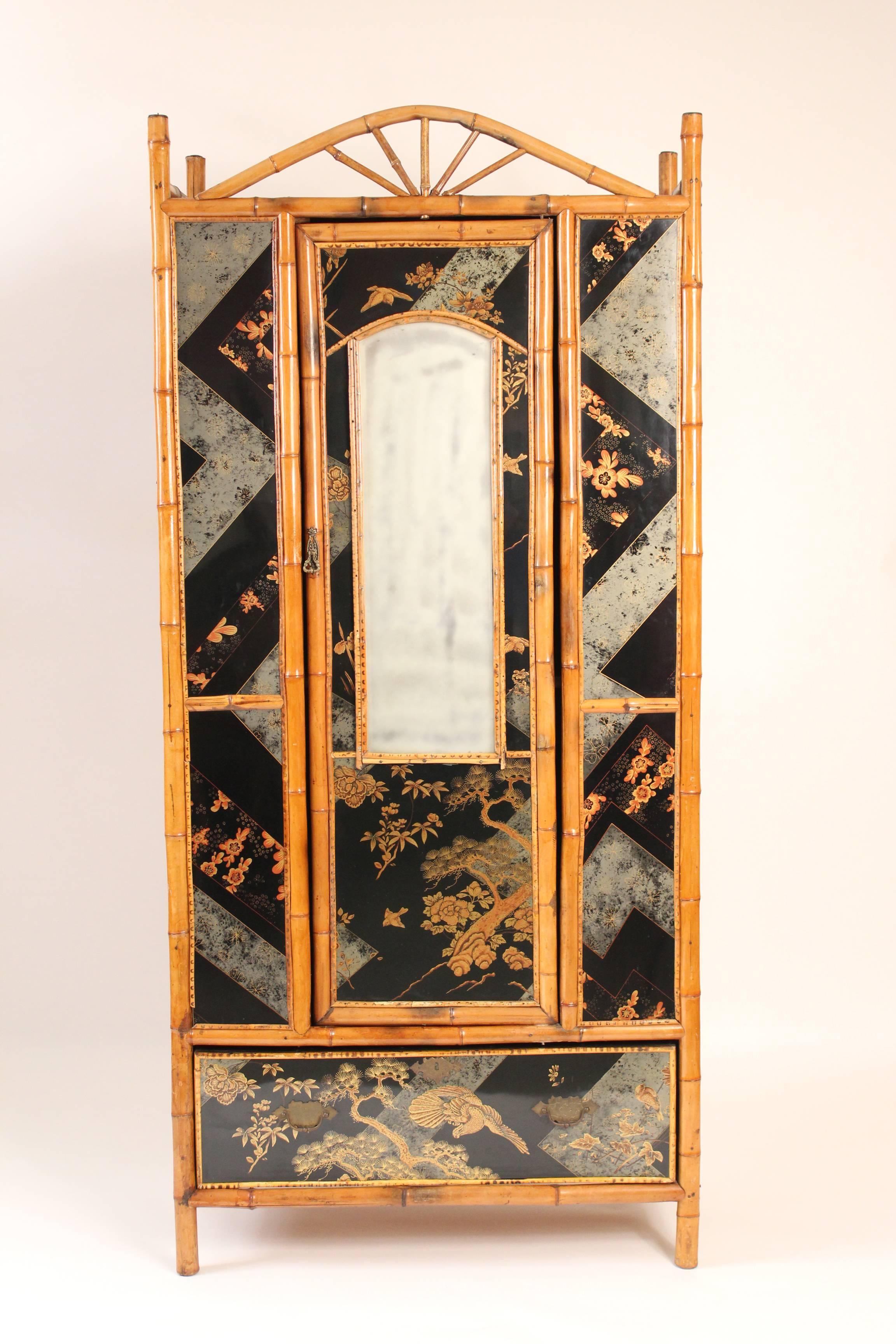 Chinoiserie decorated and bamboo armoire, circa 1930. This armoire has raised decorations and a high gloss finish.