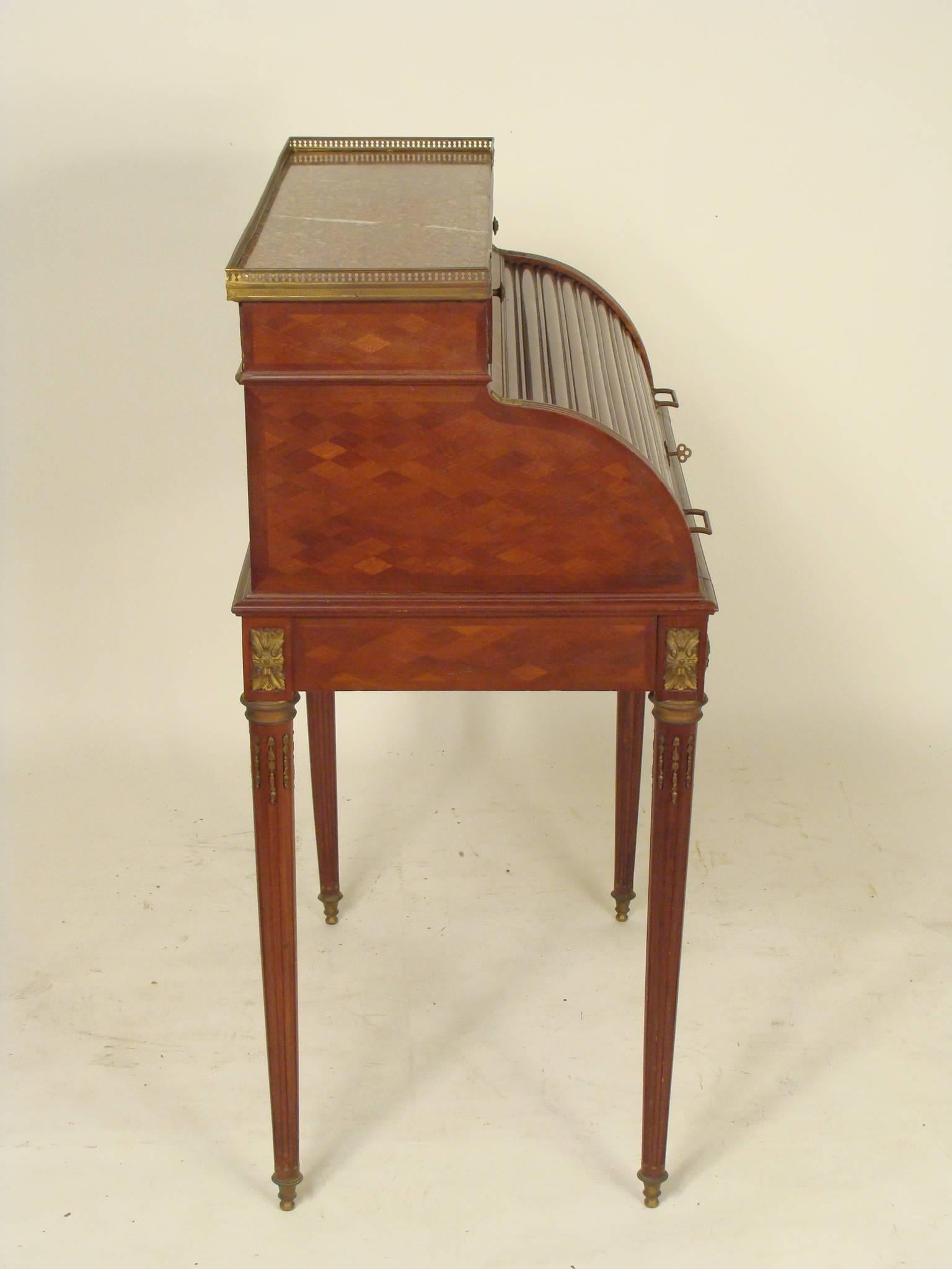 Louis XVI style mahogany cylinder desk with bronze mounts and a marble top, circa 1920. This desk has a nice quality bronze mounts, a Fine quality marble top, tambour cylinder and a pull-out tooled leather writing surface.