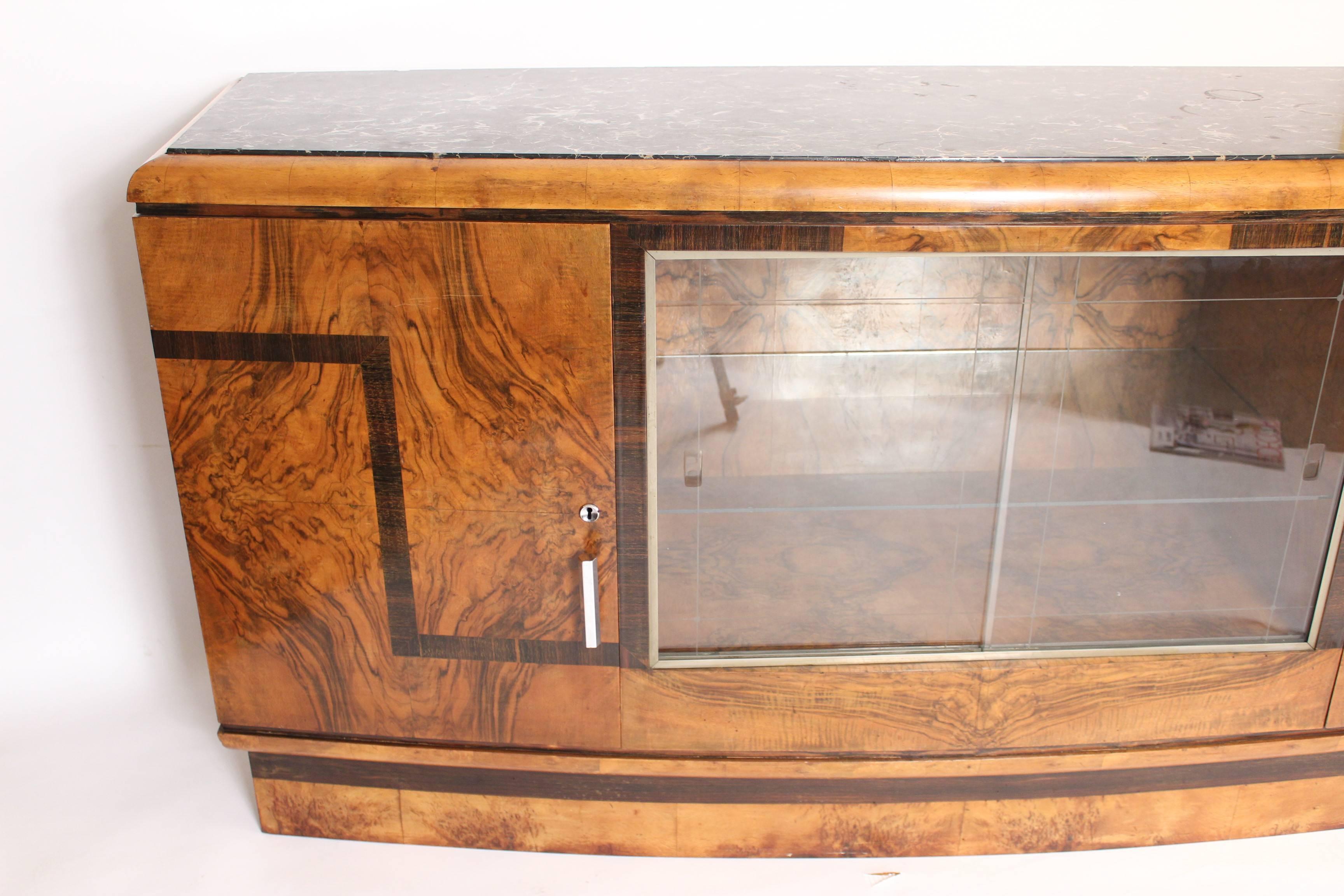 Art Deco burl walnut sideboard with sliding glass doors and a marble top, circa 1930s. This sideboard has exceptionally fine burl walnut used throughout. The top is Belgium marble. The hardware is nickel plated.