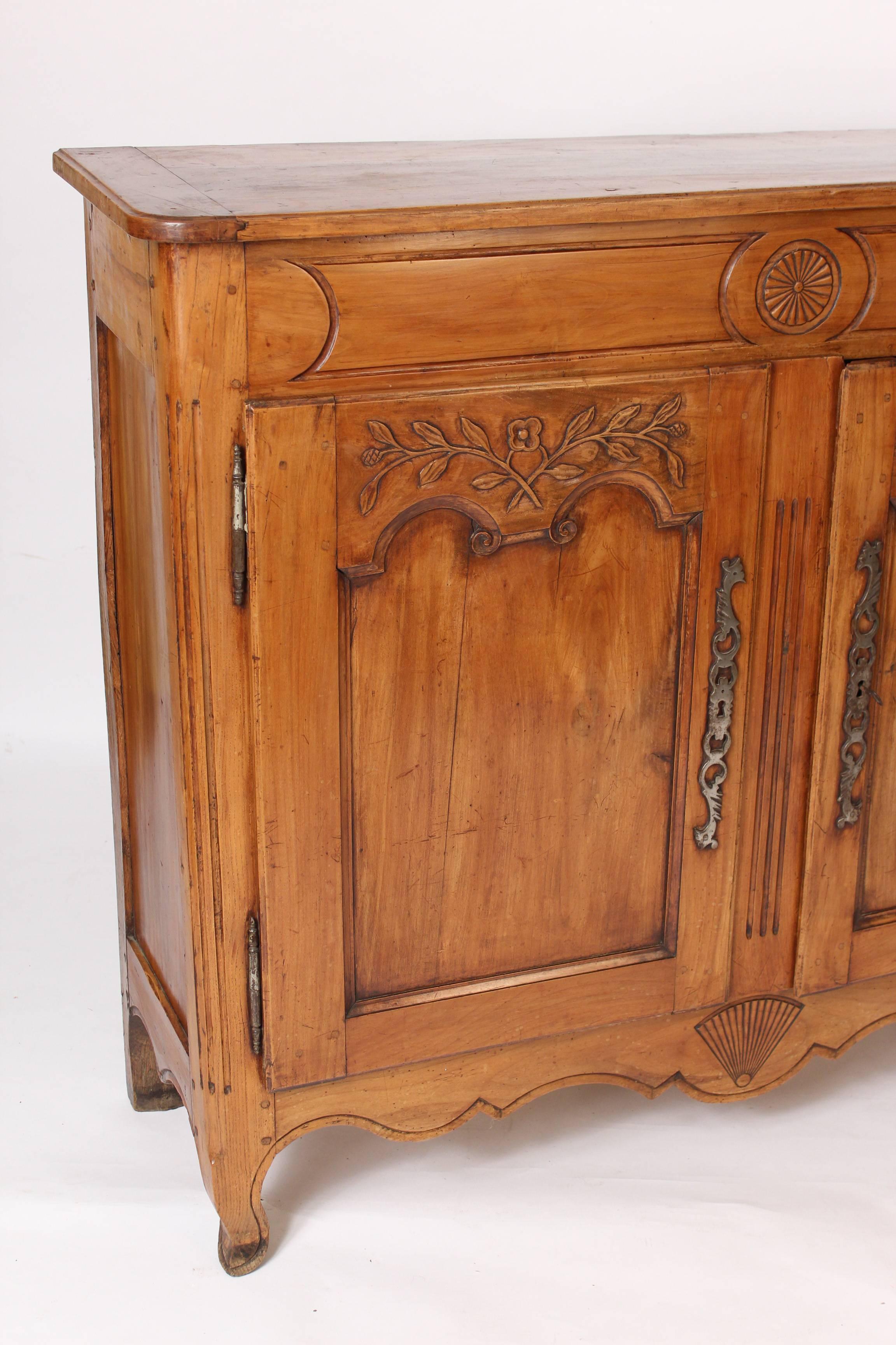 Louis XV Provincial fruit wood buffet with doors, early 19th century. Central carved patera in the frieze, foliate carved doors and a central fan carving in the apron. Nice fruit wood color. Steel escutcheons and hinges. 