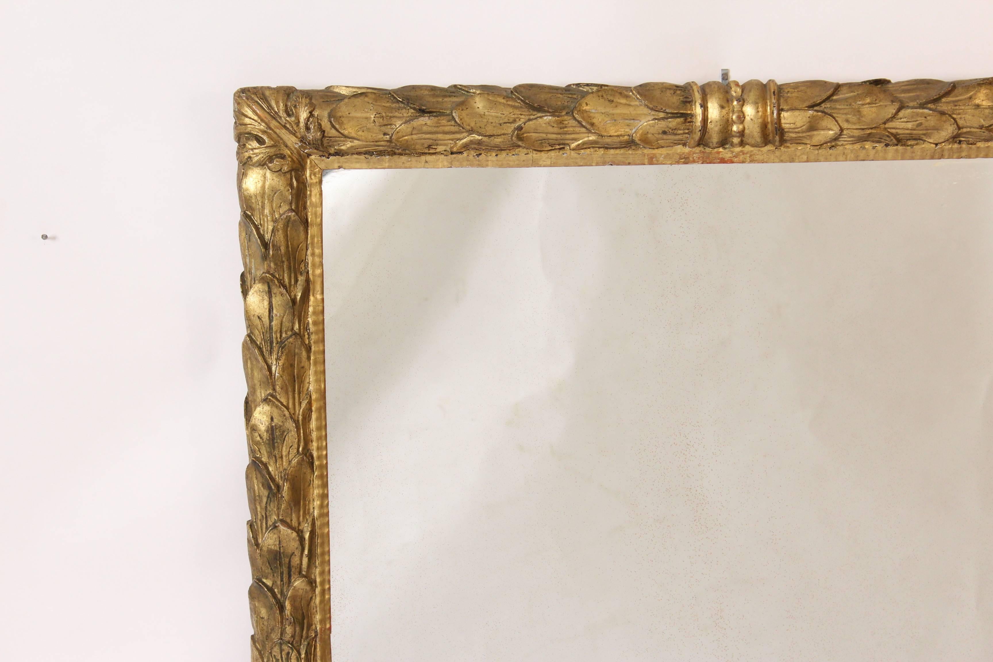 Antique Baroque style floral carved giltwood mirror, 19th century. This mirror has a nice old gilt finish.