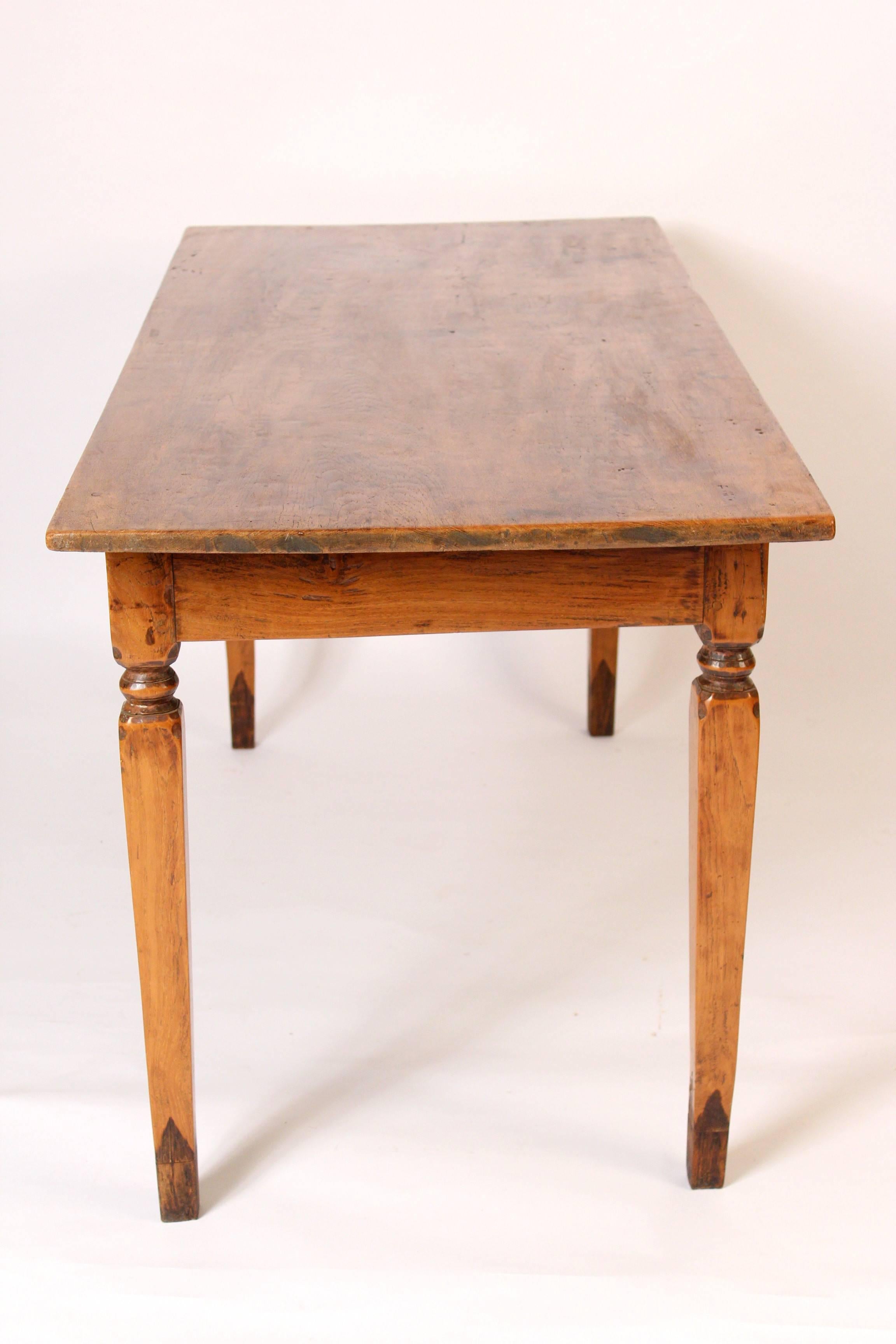 Antique French farm table with a single board top, late 19th century. The feet have been tipped. The wood on this table has excellent color / patina.