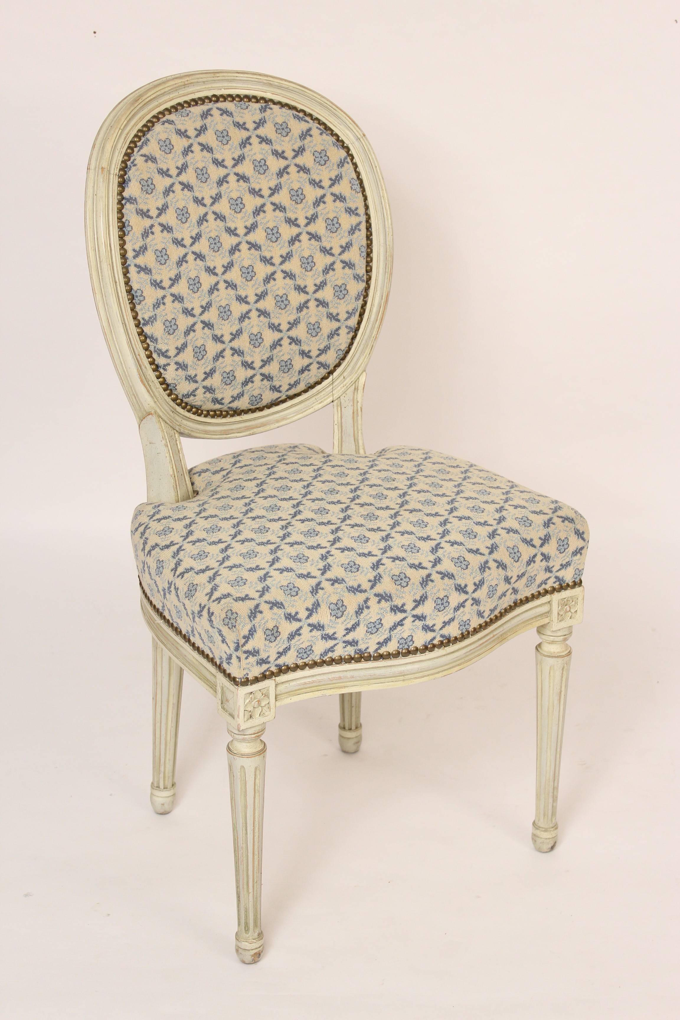Set of four Louis XVI style griselle painted side chairs, mid-20th century. These chairs are excellent quality with painted frames, Fine quality upholstery, brass nailheads and spring seated inner construction.