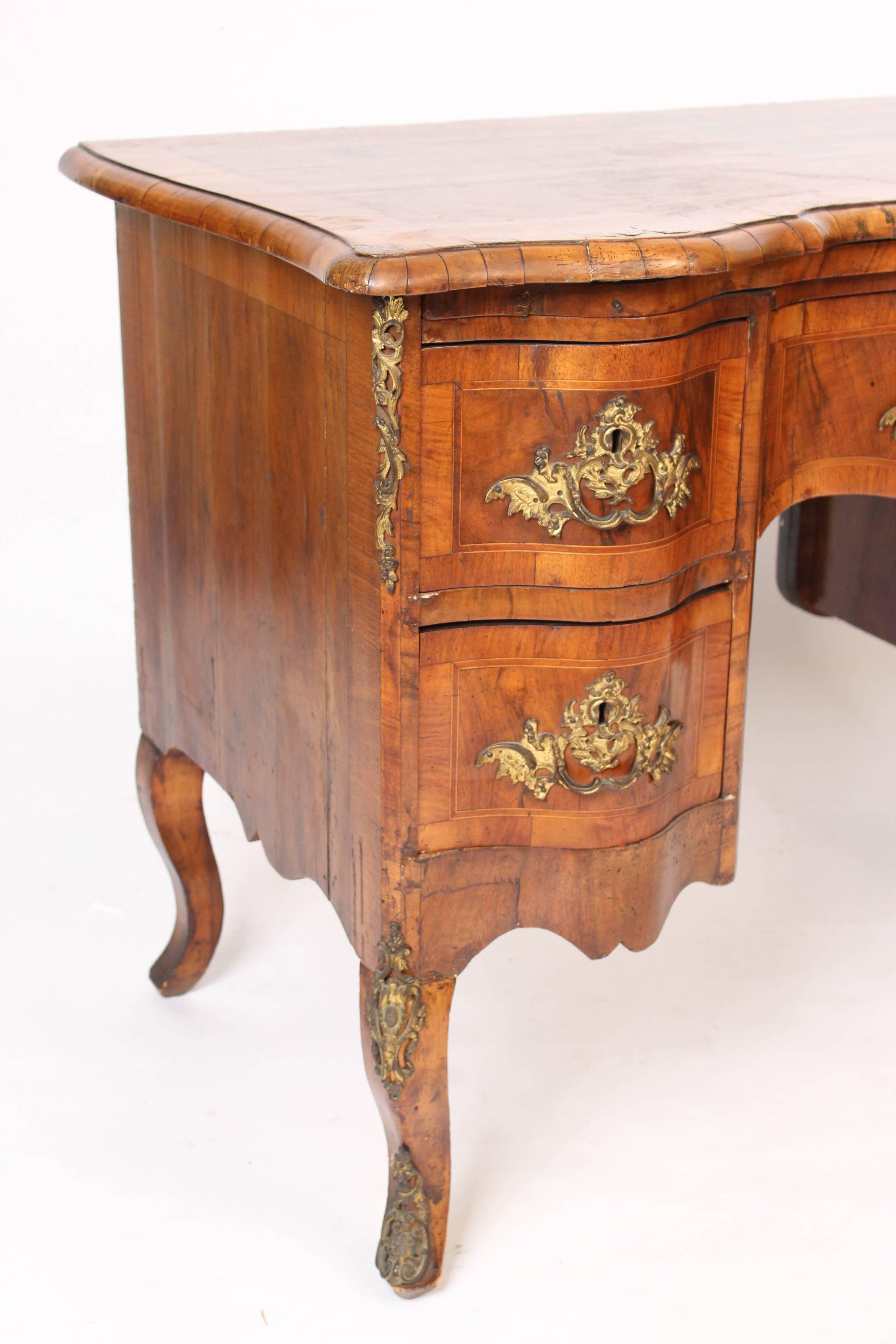 Louis XV style burl walnut knee hole desk with gilt metal mounts, circa 1900. Back side is finished so that it can float in the center of a room.