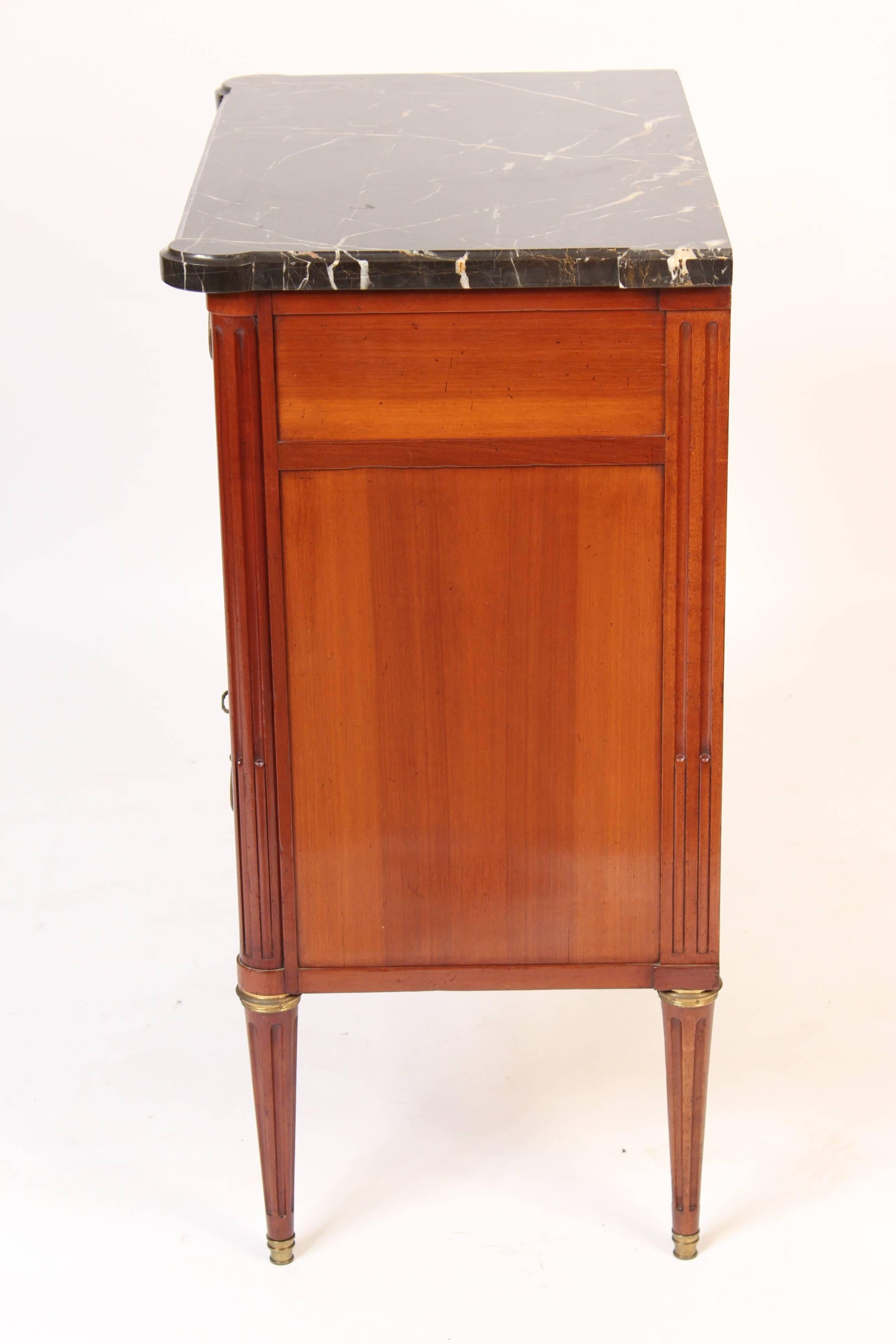 Louis XVI style mahogany chest of drawers with brass hardware and a marble top, made in France, mid-20th century.