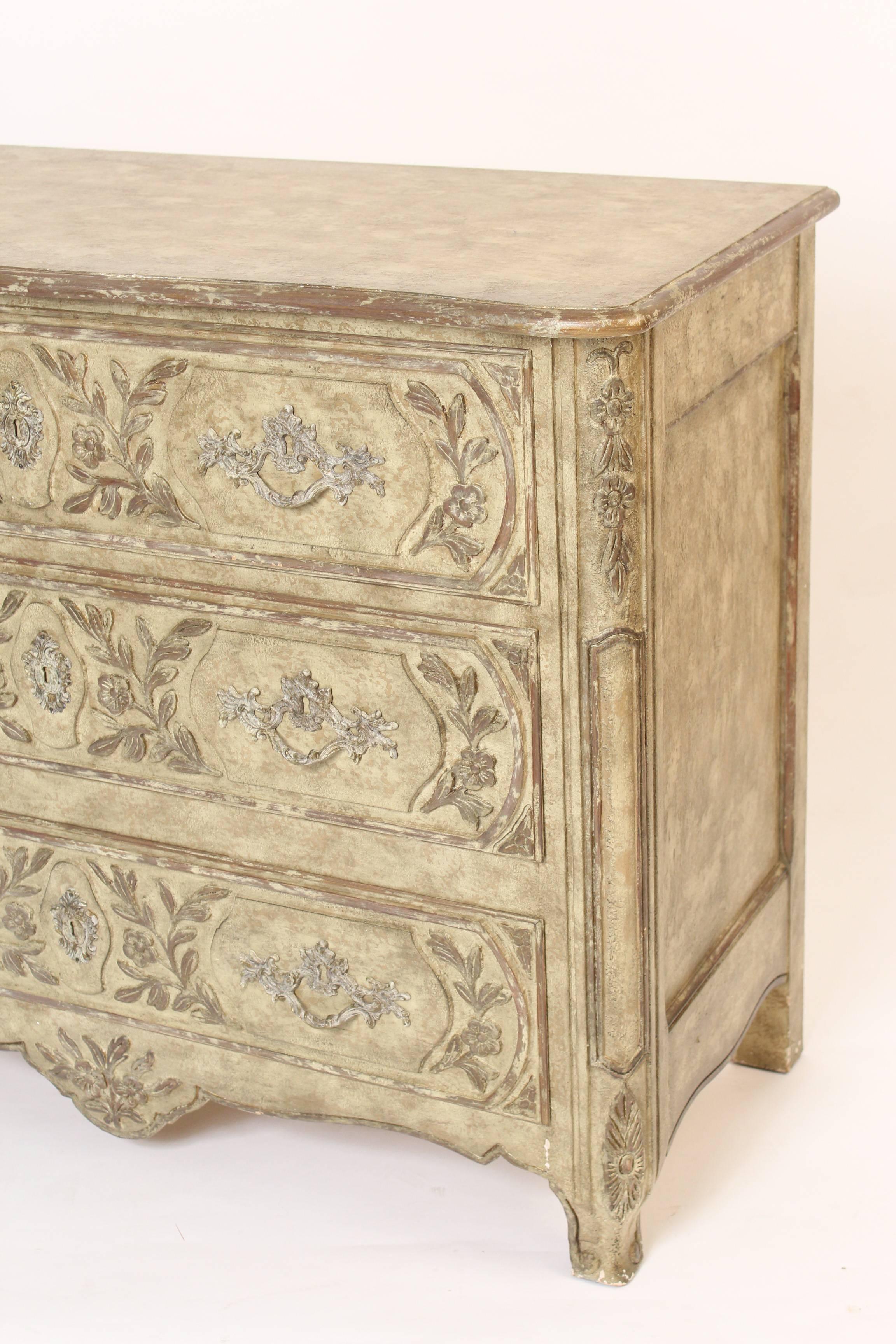 Louis provincial painted commode , made by Baker, late 20th century. Features on this commode include, a serpentine shaped top, nice crusty painted surfaces, carved raised floral decoration on the drawers and  Louis XV style brass hardware.