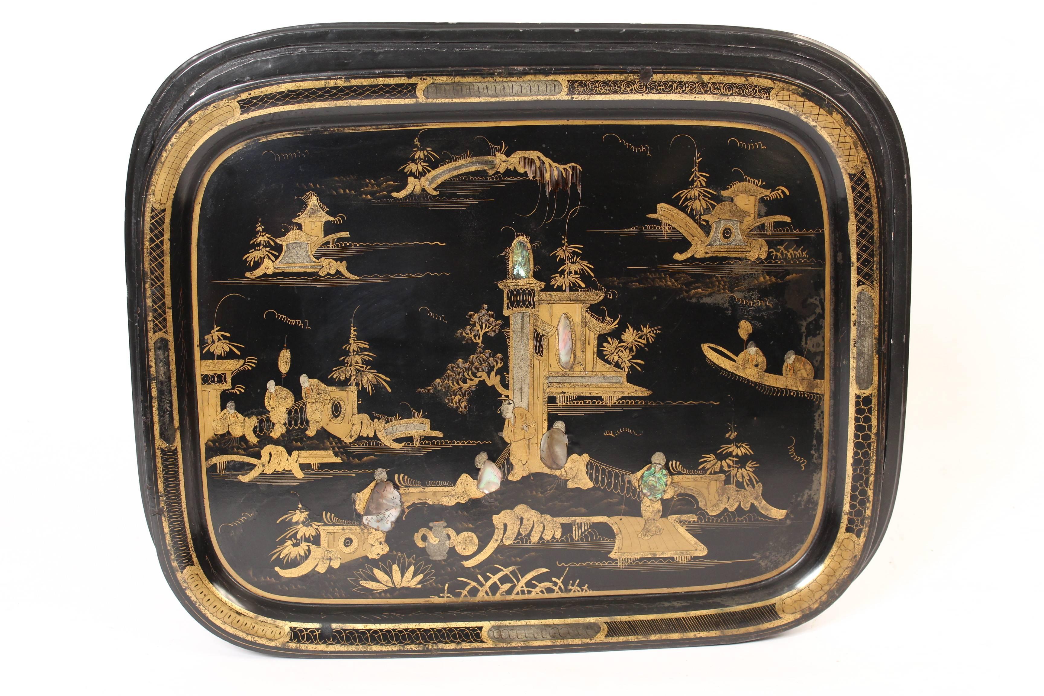 Late 19th century tole tray with chinoiserie style gilt decorations and mother of pearl highlights, circa 1890. The English regency style black lacquer and gilt decorated bamboo turned base is late 20th century.