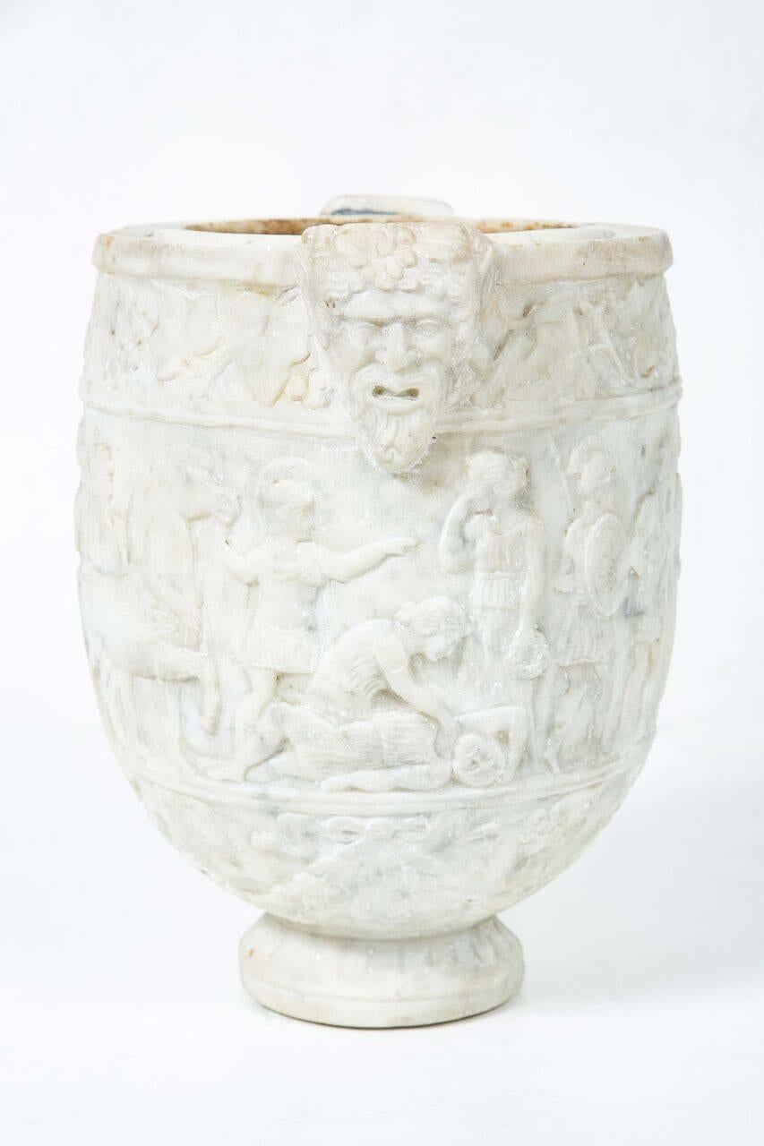 Beautifully carved, Roman, marble urn featuring reliefs of robed figures and robust masks, possibly of gods. From the Ravello, Italy estate of writer and public intellectual, Gore Vidal (1925- 2012).