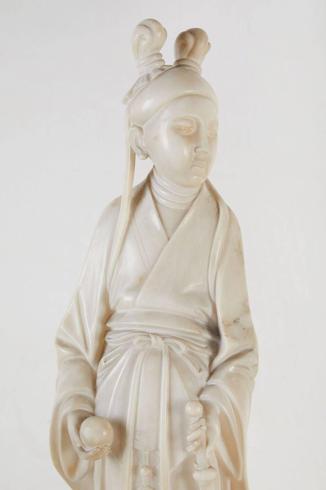 Scultura italiana, scolpita a mano, di un grazioso Kwan in abiti fluenti. La figura poggia su una base ottagonale in alabastro massiccio ed è montata su una grande colonna scanalata d'epoca in legno intagliato.

Da un sito online dedicato alle