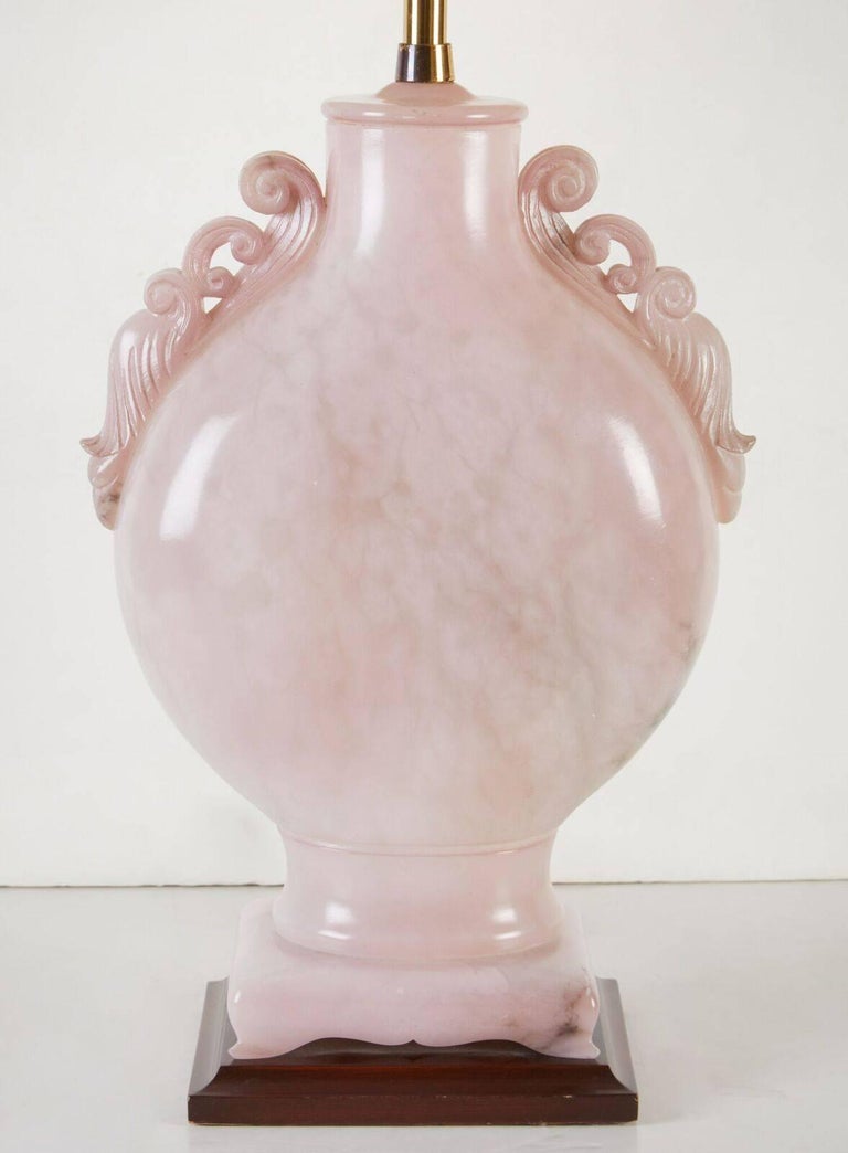 Large, Asian influenced, solid pink alabaster lamp with pierced, faux armatures, matching foot and finial. The whole atop a veneered, wood base. Made by the famed Los Angeles based, Marbro Co. which closed it's doors in the 1990. 

From 