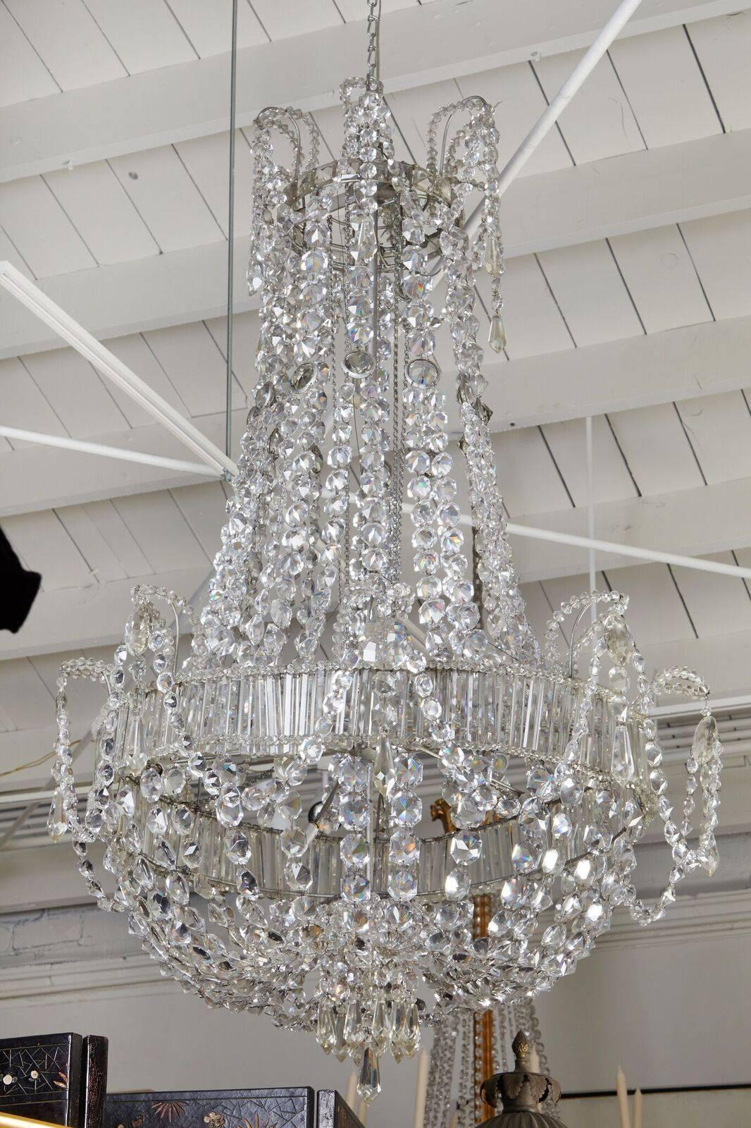 Grand, hand-made, crystal chandelier with gathered, central basket encircled by a band of horizontal crystals and swaddled with crystal swags. The piece is wired for U.S. current and is has sockets for six bulbs.