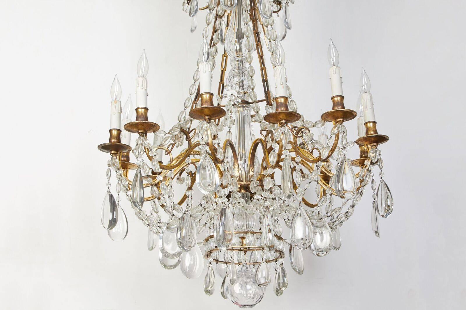 Elegant, circa 1900, French, gilt bronze, twelve-arm chandelier with generous layers of crystal swags and large drops of the same. Wonderful patina. Wired for U.S. current.