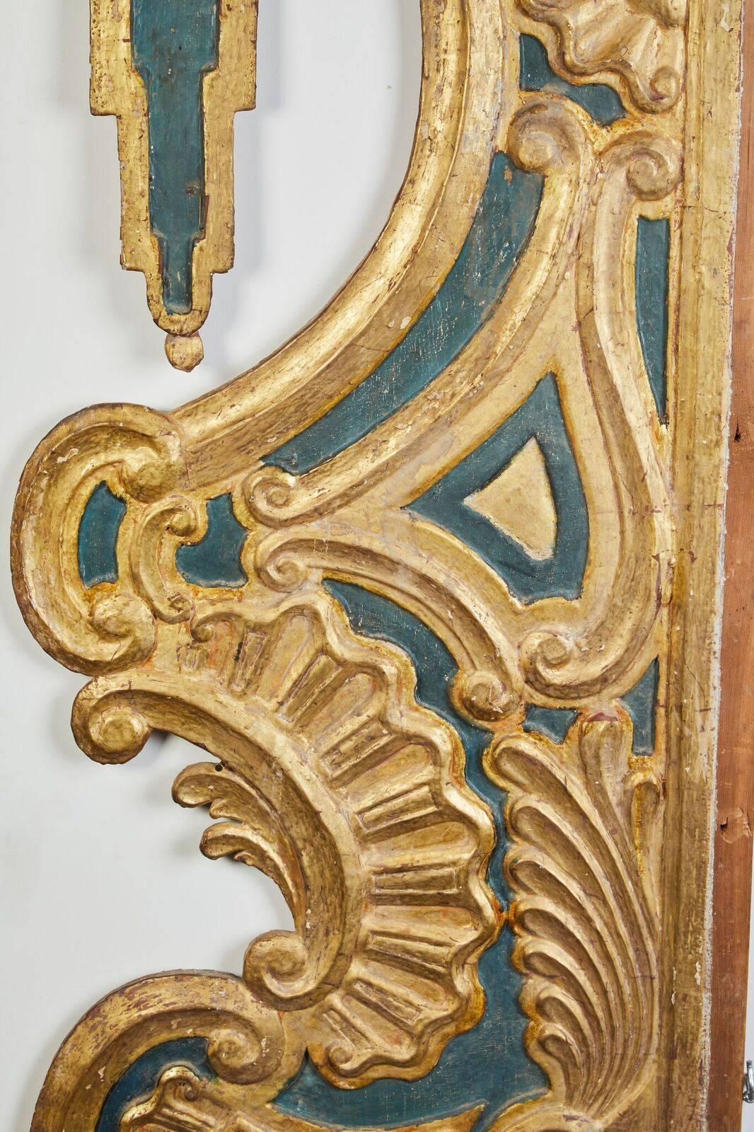 Pair of left and right, elaborately hand-carved, painted and gilded, undulating, wood door surrounds from a Venetian palazzo. The relief carving consists of scrolls, shell-like motifs and a pair of 