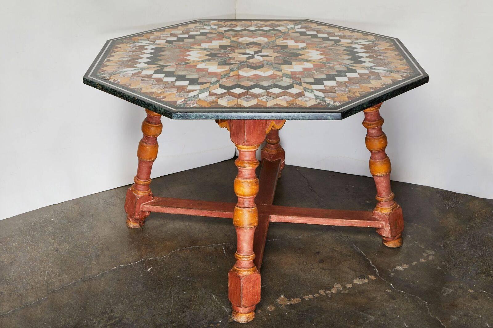 Table surdimensionnée, spectaculaire, octogonale, toscane, datant des années 1930, en marbre spécimen, sur une base peinte, à pieds tournés avec un étrier en X.