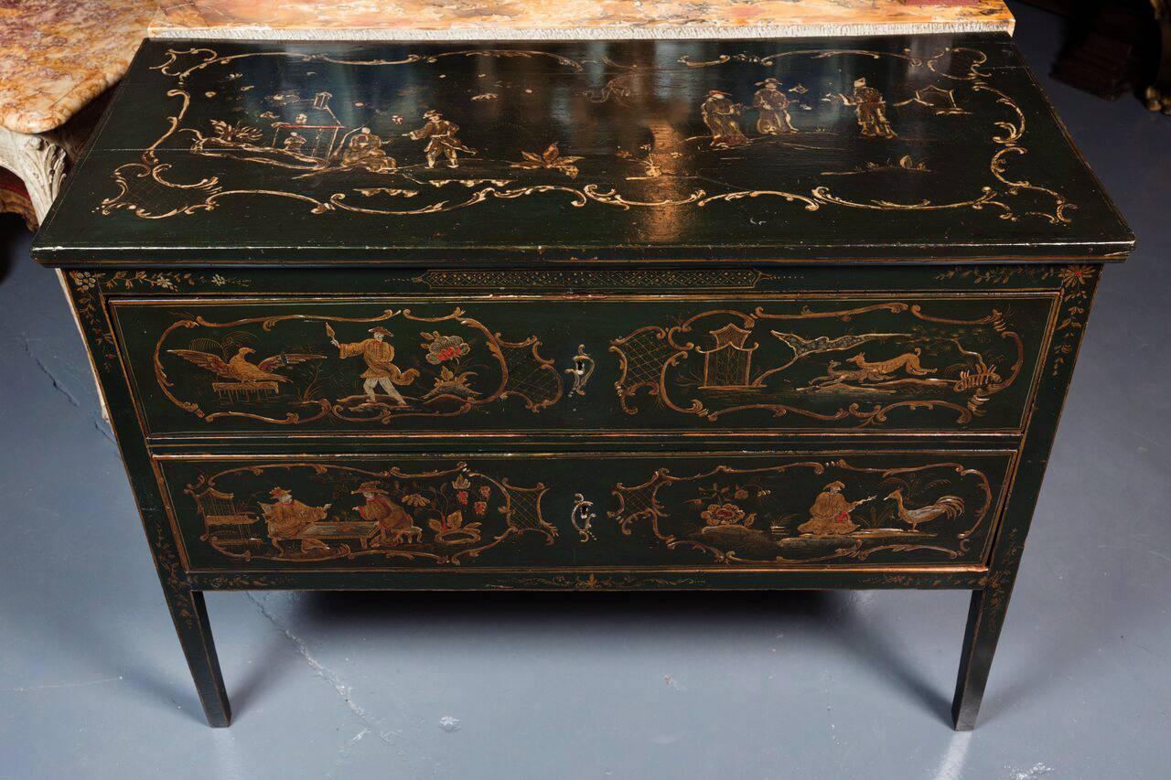 Hand-carved and painted, parcel-gilt, lacquered, two-drawer, Italian, chinoiserie commode featuring a variety of vignettes bordered by foliate frames.