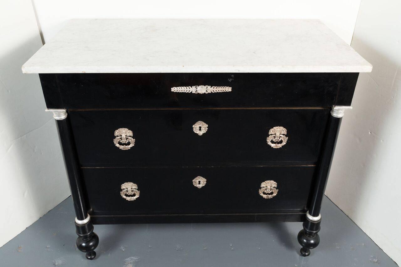 Hand-carved and finished, Northern Italian, three-drawer Neoclassical commode with white, Carrara marble top above pilaster fore-legs trimmed in silver gilt. The whole embellished with silver escutcheons.