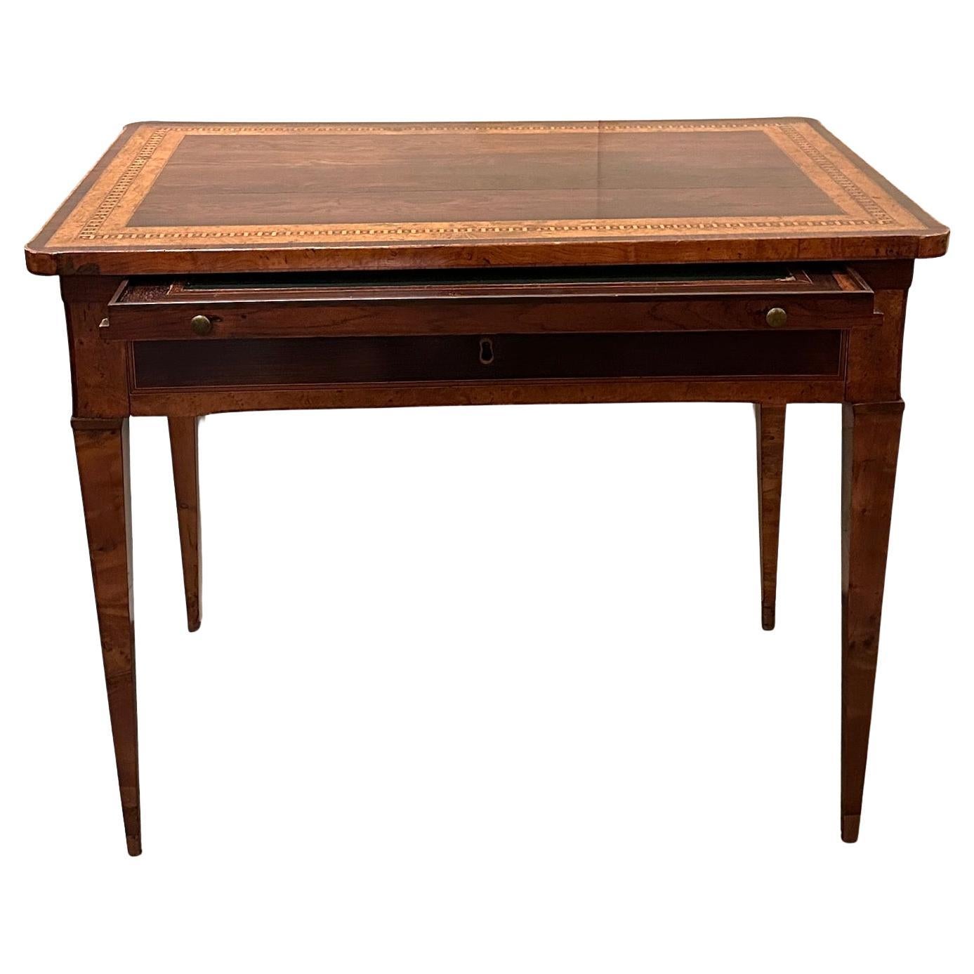 Magnifique et inhabituelle table à écrire en noyer et bois d'olivier plaqués et incrustés, comprenant un plateau coulissant, un bureau extractible et un tiroir, le tout reposant sur des pieds fuselés.  Tirettes en bronze.