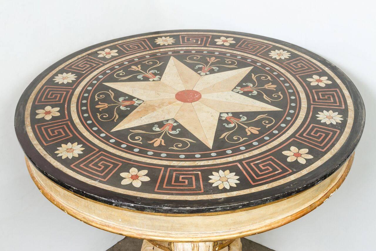Round, scagliola marble-top above a hand-painted, parcel-gilt base featuring paw feet and foliage details.