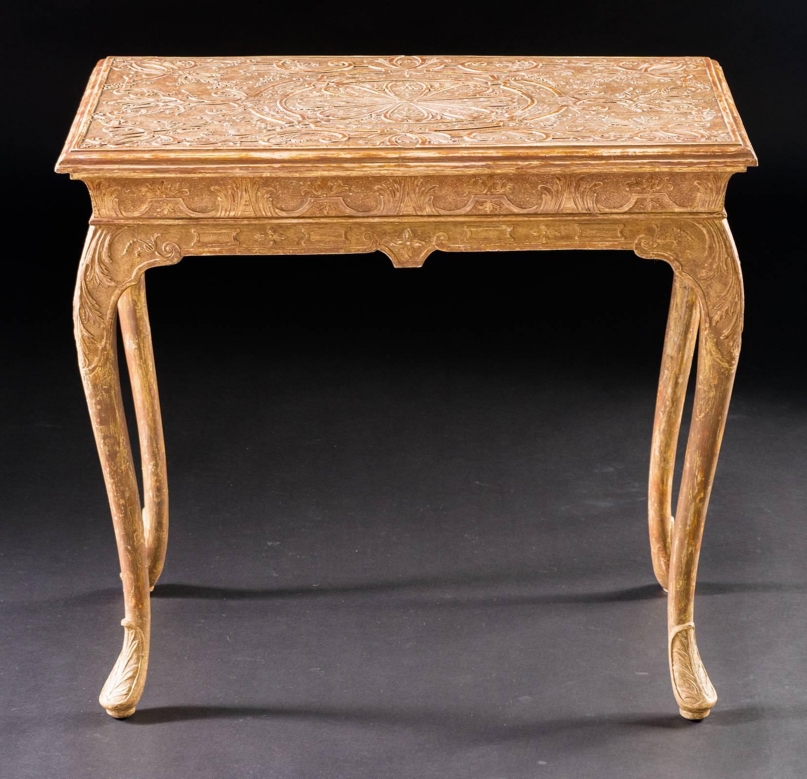 The molded rectangular top with a carved stylized central floral roundel incorporating finely carved bellflower swags, set within foliate strap-work, on punched ground; the shaped apron having conforming decoration, raised on cabriole legs ending in