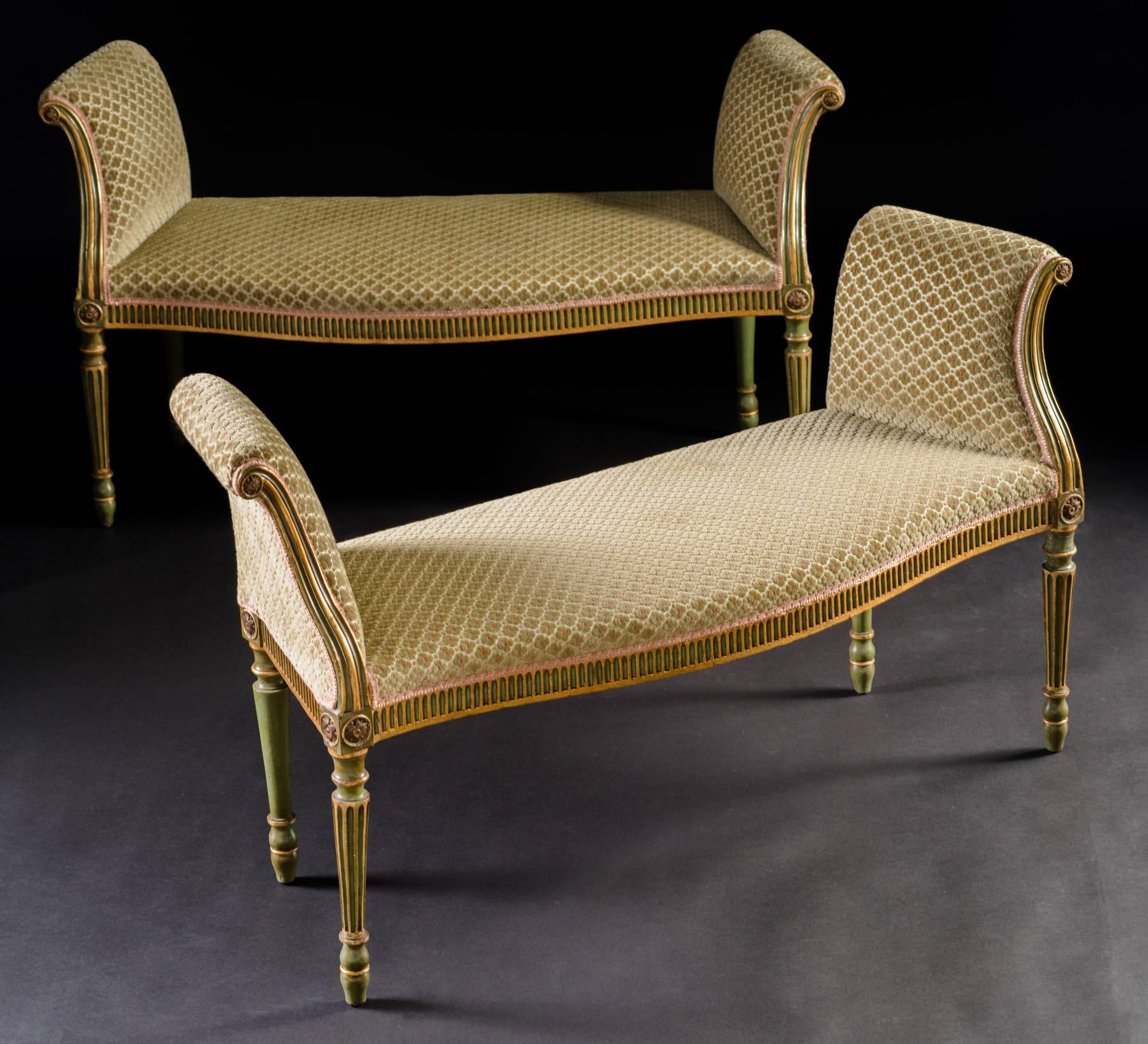 The serpentine-front rectangular seat with outscrolled padded armrests over a flutted frieze and raised on fluted turned tapering legs ending in toupie feet.