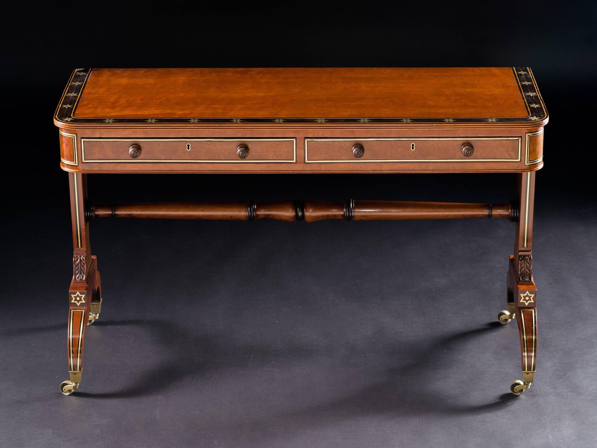 The hinged top with ebony and brass inlaid star border, above two cedar-lined frieze drawers; the trestle end supports with brass inlay throughout joined by an ebony banded turned stretcher, raised on conforming down-swept legs ending in brass caps