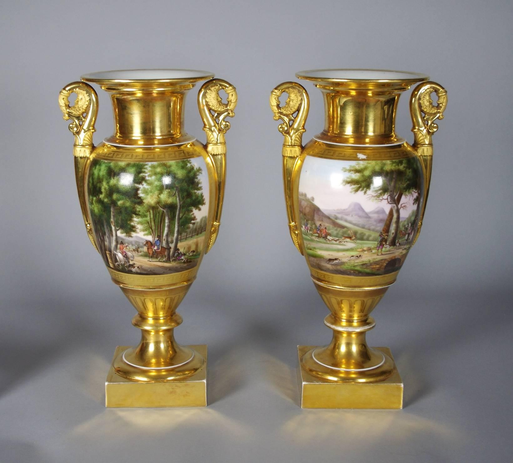 Fine pair of Old Paris porcelain vases, each with overall gilding and well painted with hunting scenes, the elaborate handles with molded faces.

The decoration on these wonderful vases depicts various hunting scenes. The traditional landscapes in